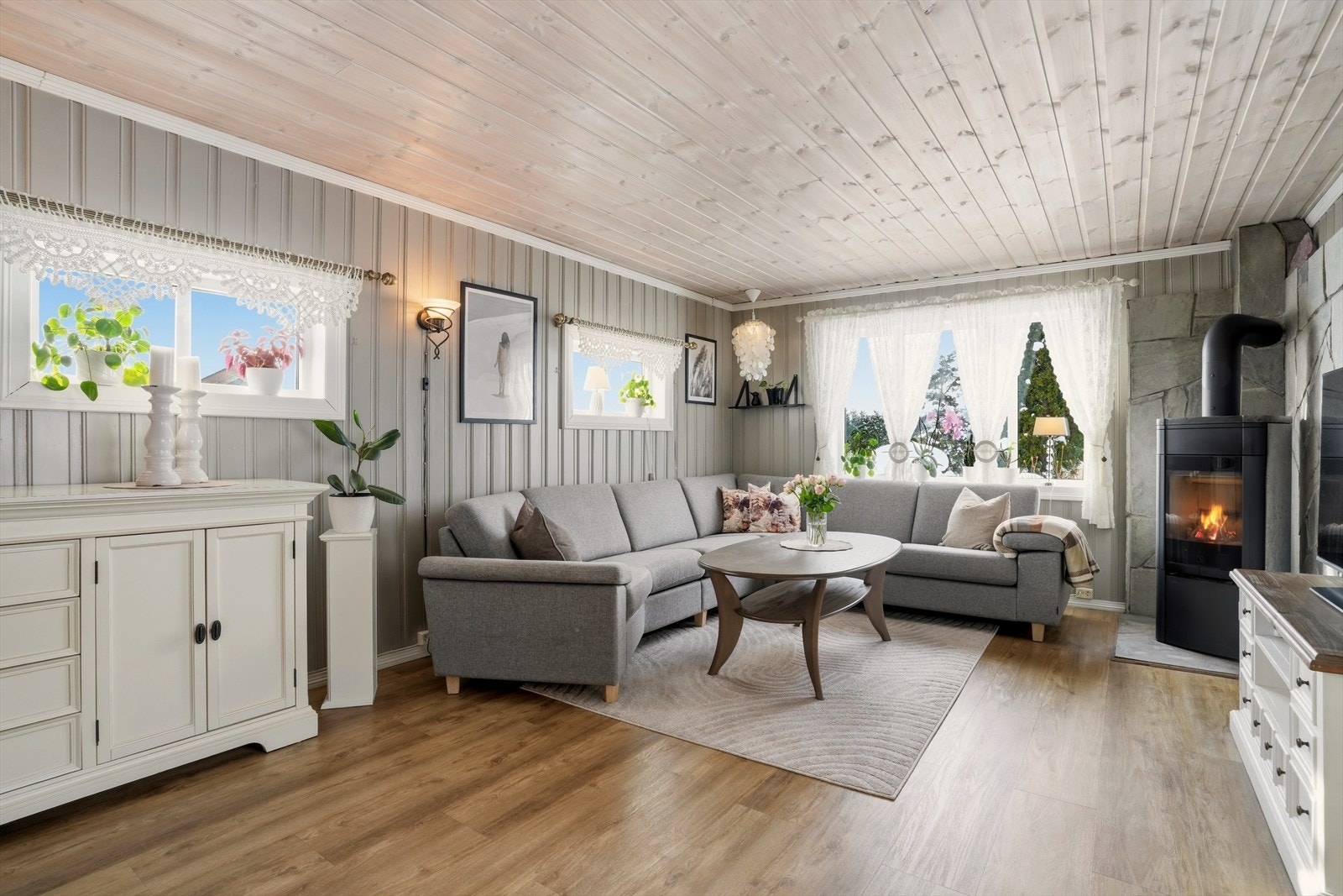 Stuen er romslig med laminat på gulv og malt panel på vegg. Galleribilde