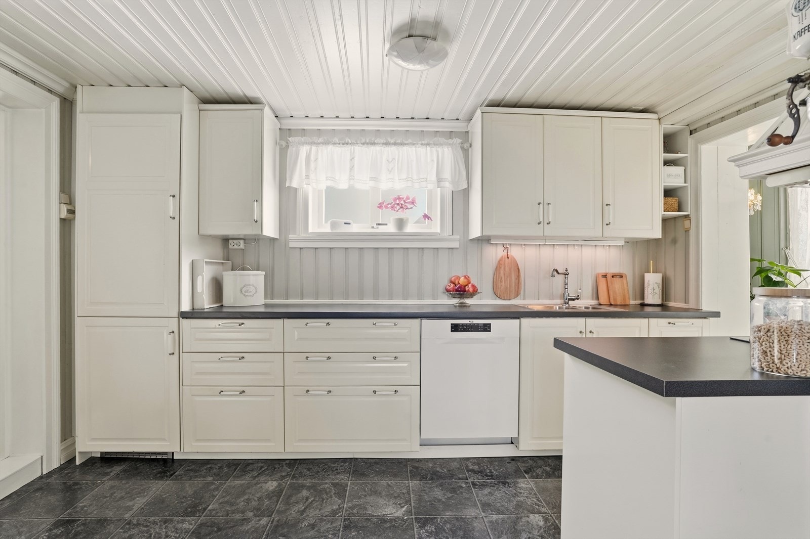 Kjøkkeninnredningen har profilerte fronter, laminert benkeplate, vaskekum, nedfelt platetopp, ventilator, stekeovn, oppvaskmaskin, og kjøl/frys. Det er kjøkkenventilator med avtrekk ut. Galleribilde