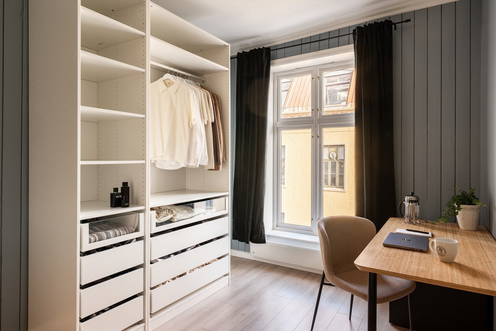 Langs den ene veggen er det etablert en åpen garderobeløsning med rikelig oppbevaringsplass i hyller, skuffer og heng. Galleribilde