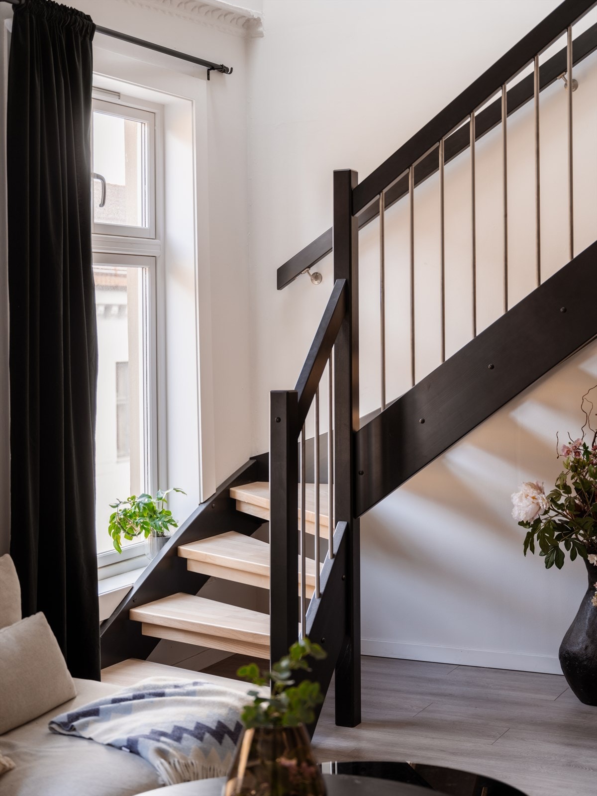 Tretrapp med malte vanger og åpne eik inntrinn mellom etasjene. Galleribilde