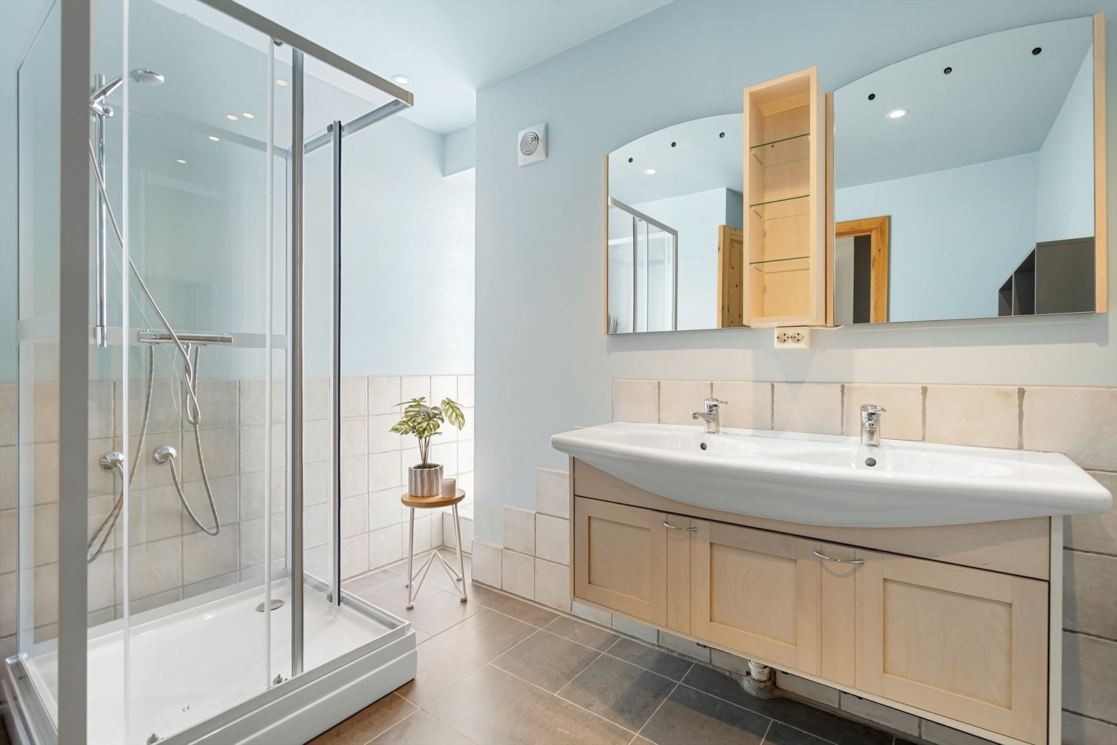 Badet er utstyrt med dobbeltservant, dusjkabinett, toalett, varme i gulv og spotter i tak Galleribilde