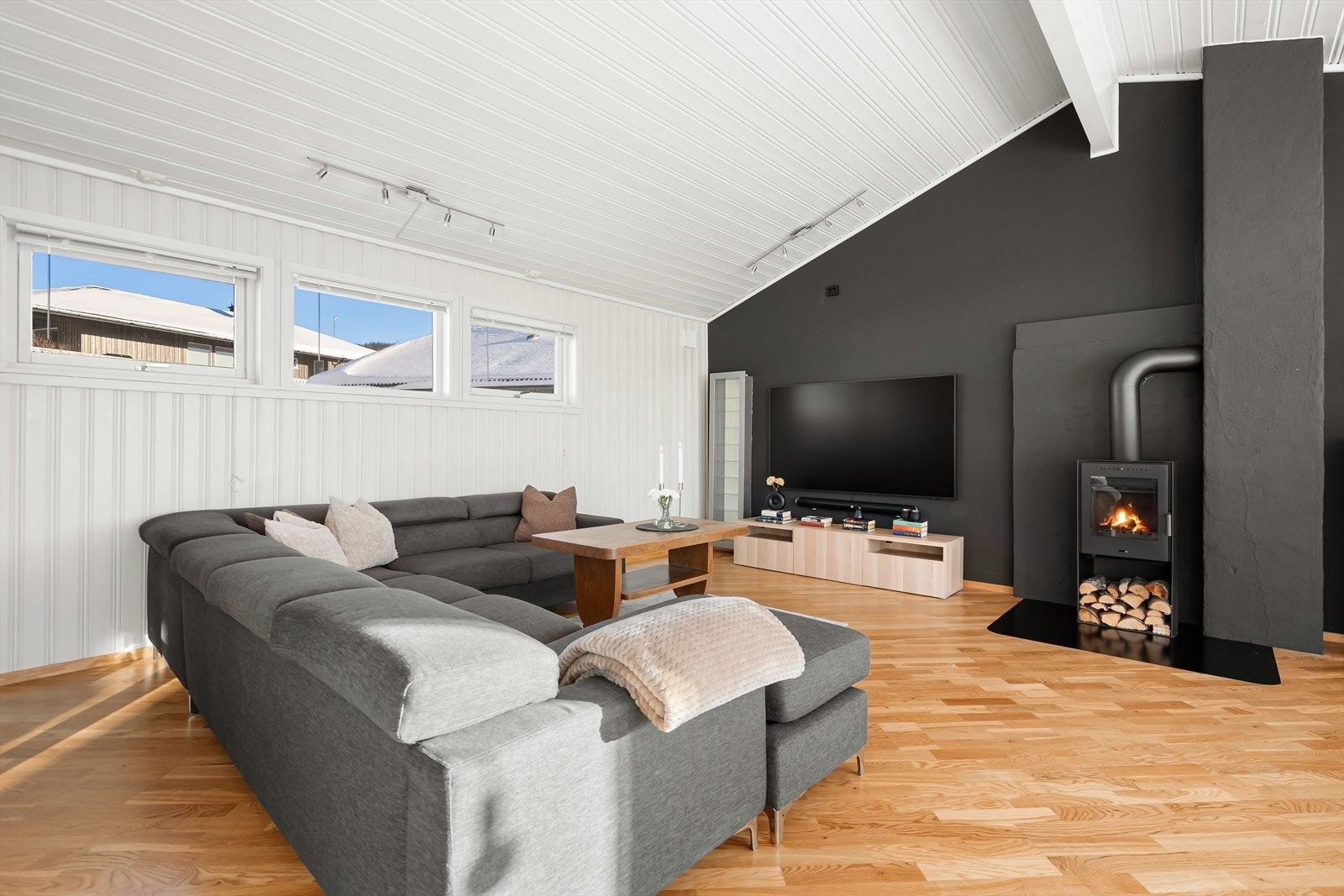 Innbydende stue koselig vedovn og naturlig plassering av mediemøblement og sofa Galleribilde