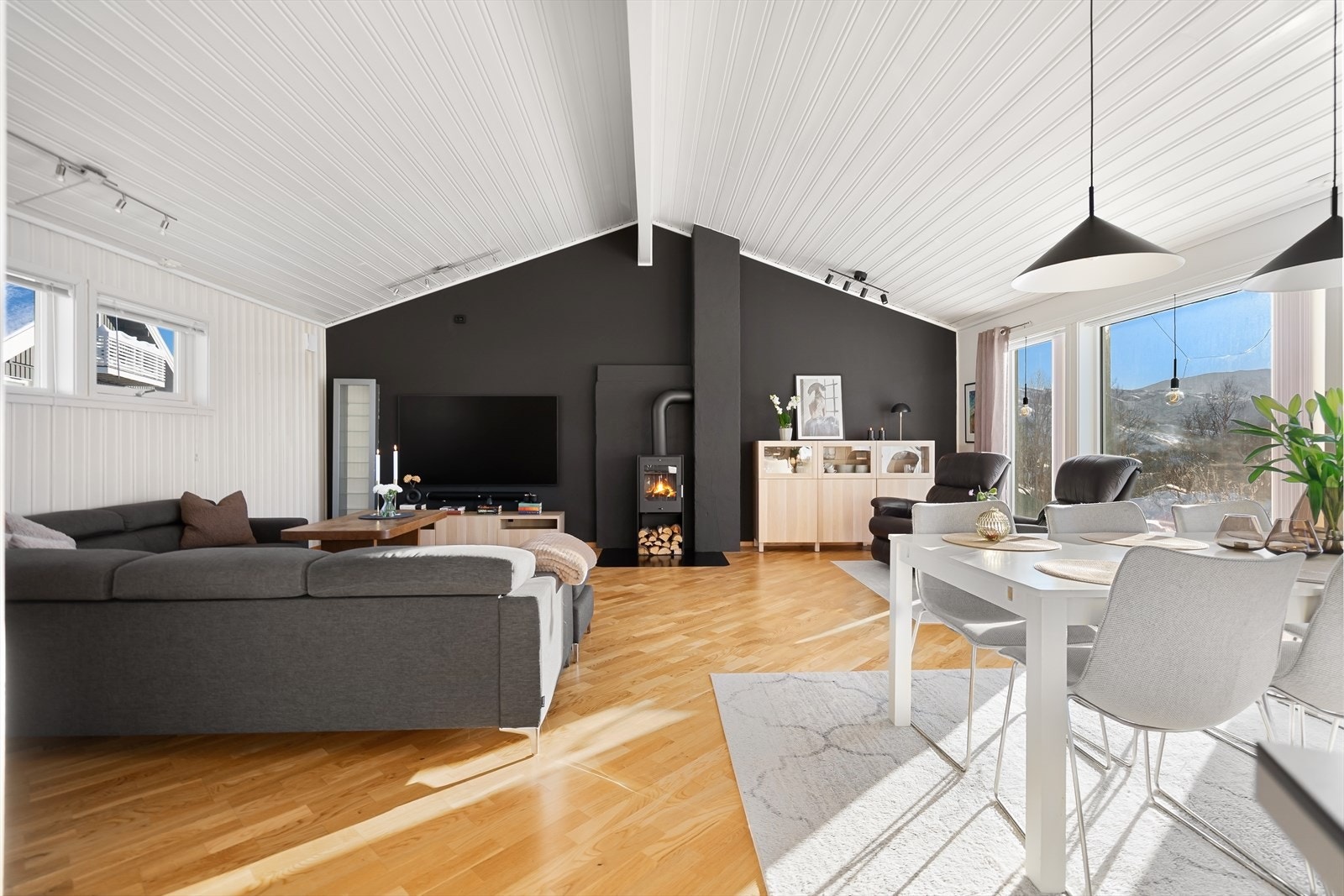 Flott, åpen stue med ekstra takhøyde og store vinduer i hele front - lyst, luftig og perfekt for både hverdag og sosiale sammenkomster Galleribilde