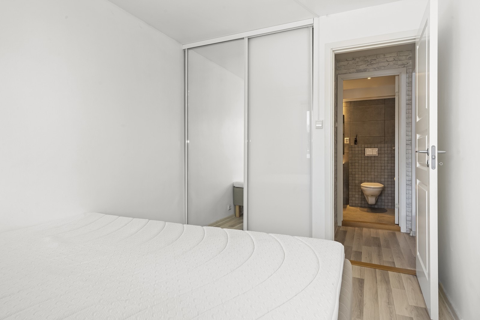 En praktisk skyvedørsgarderobe med speilfronter gir rikelig med oppbevaringsplass. Galleribilde