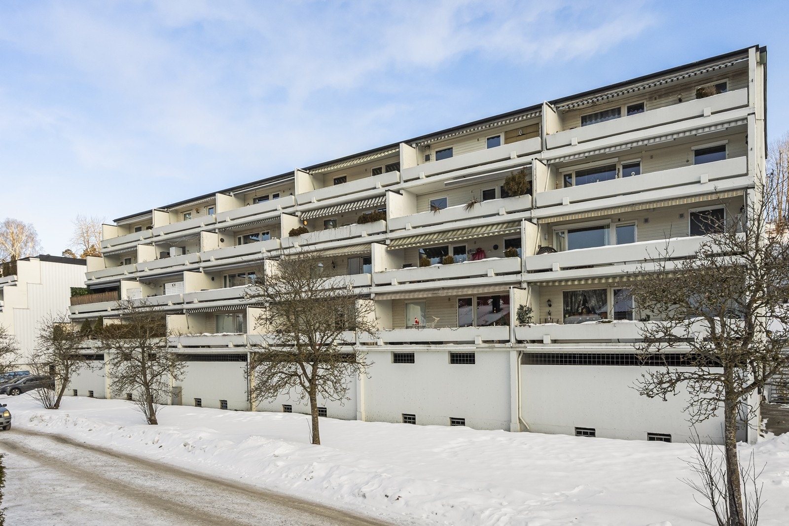 Bygget er omgitt av store, felles utearealer med plen og asfalterte gangveier. Galleribilde