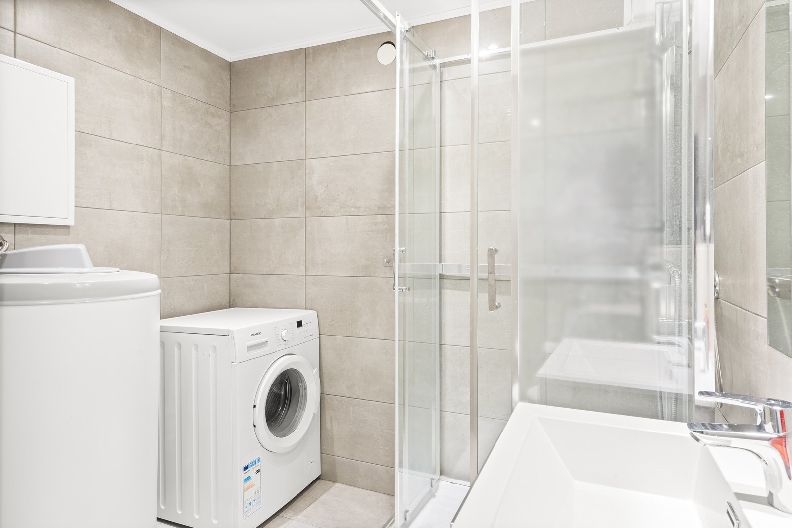 Rommet er kombinert vaskerom med opplegg for vaskemaskin og en 200-liters varmtvannsbereder fra 2018. Galleribilde