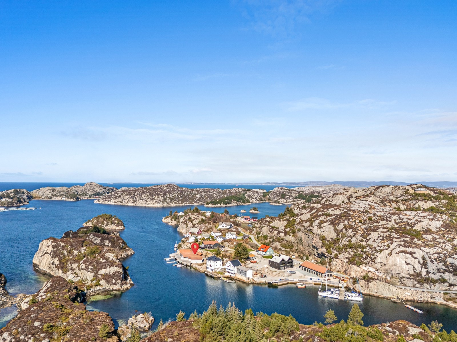 Flyfoto viser naustenes plassering nær sjøen i et naturskjønt område. Galleribilde