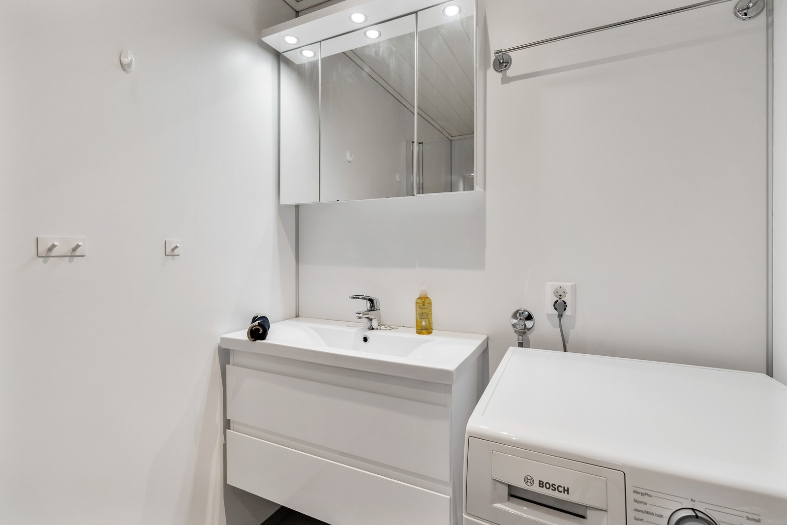 Badet er fra byggeår og har gulvbelegg med varmekabler, baderomsplater på vegger samt panel i tak med innfelte spotter. Galleribilde