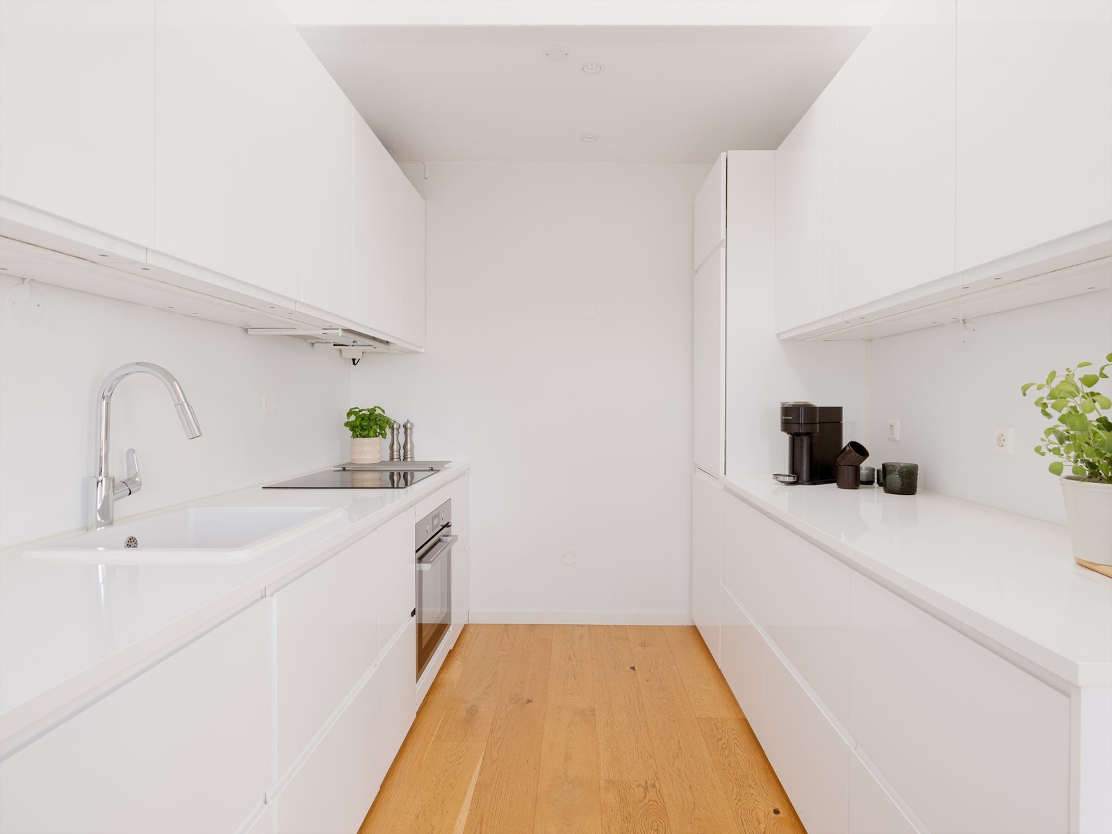 Det er rikelig med oppbevaringsplass i både skuffer og skap, og den gode benkeplassen gjør matlagingen enkel. Hvitevarene er sømløst integrert i innredningen. Galleribilde