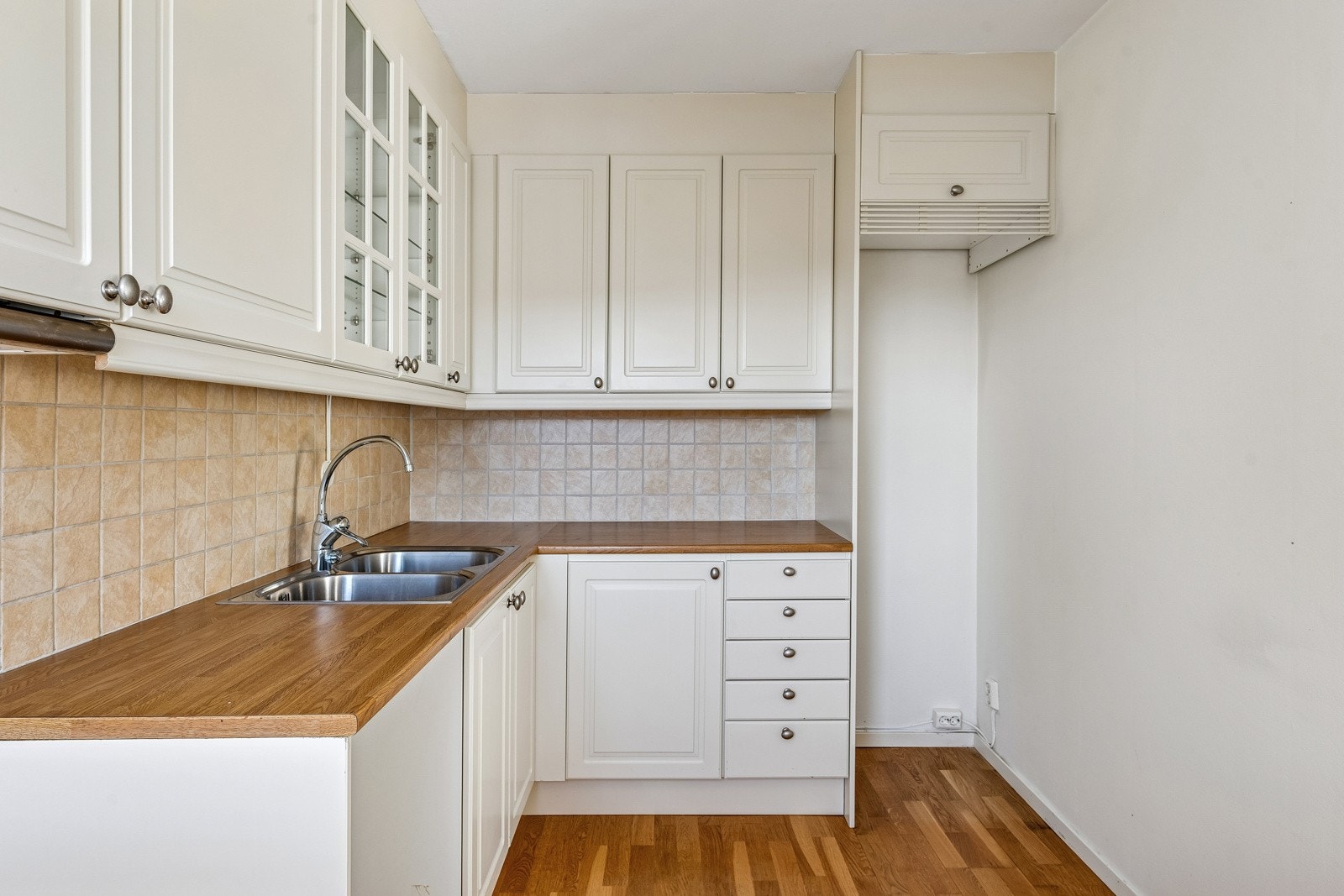 Kjøkkeninnredning med fronter fra 2009, laminat benkeplate og fliser over benk. Opplegg for oppvaskmaskin. Galleribilde