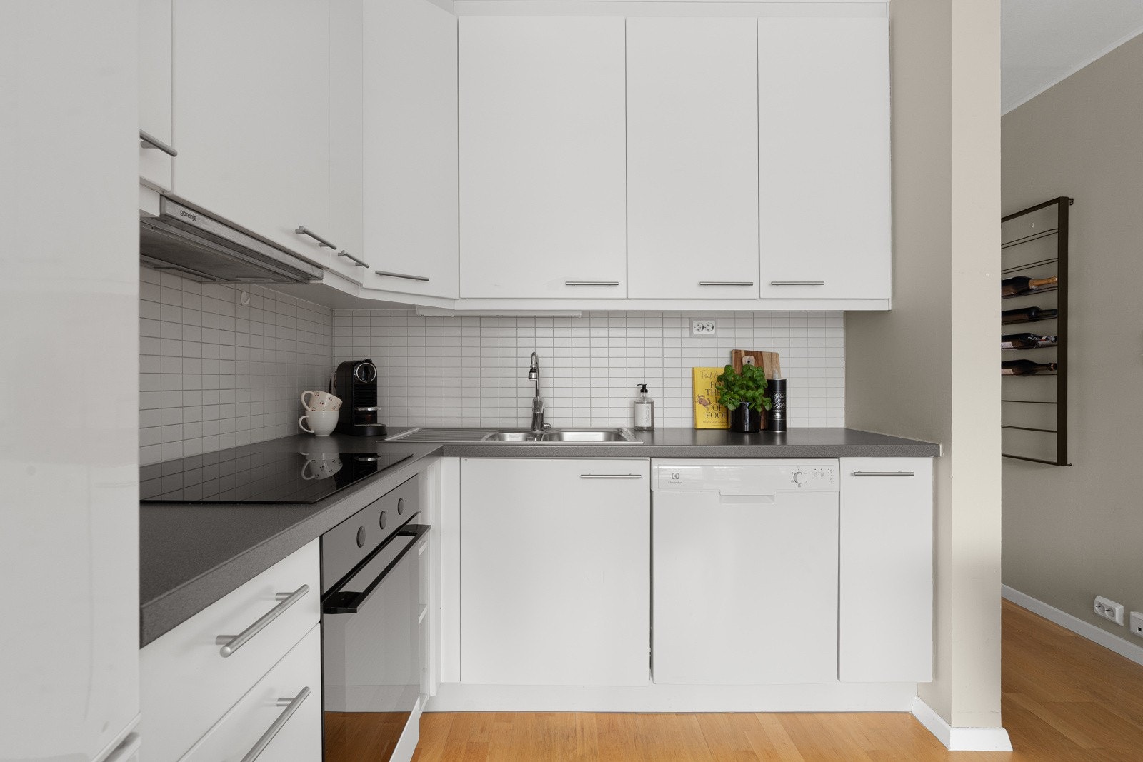 Tidløst kjøkken med glatte fronter som sikrer godt med oppbevaringsplass i over- og underskap.