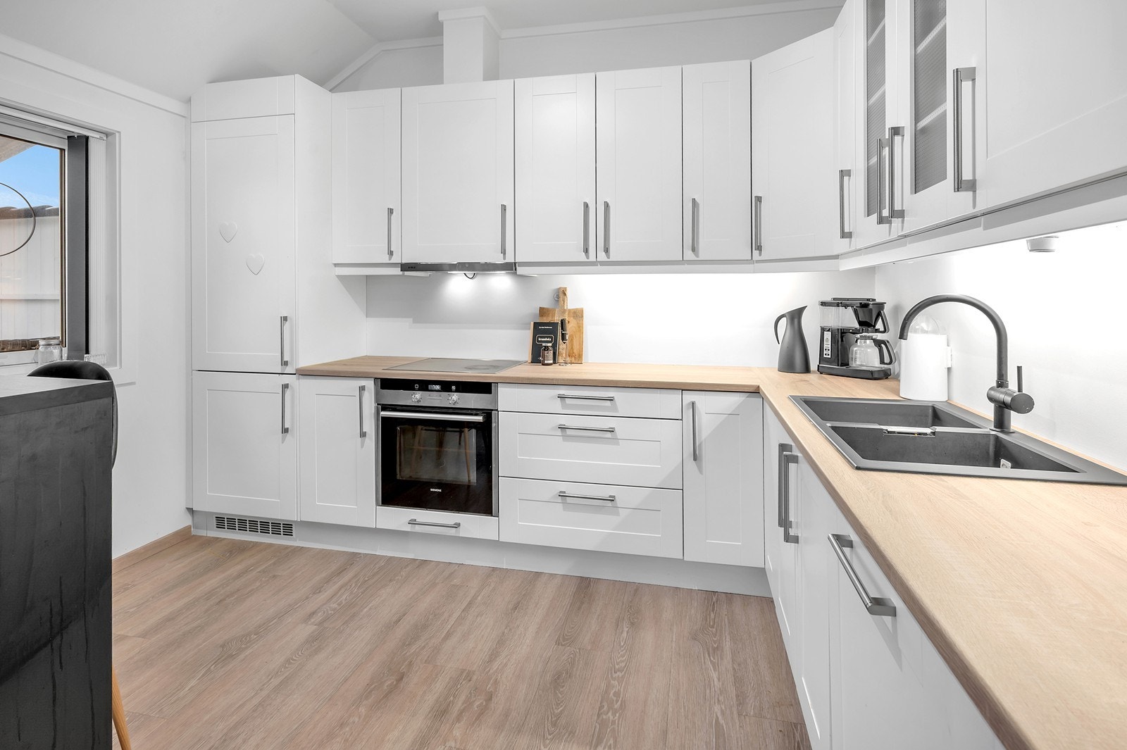 Kjøkkenet er utstyrt med integrerte hvitevarer som kjøleskap, fyrs, stekeovn, koketopp og oppvaskmaskin Galleribilde