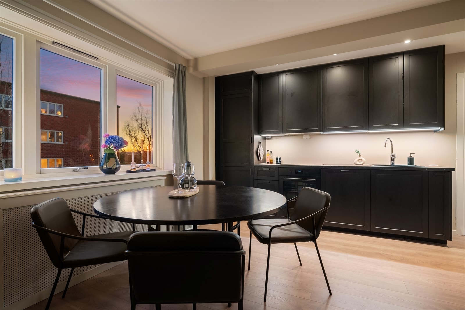 Stilrent kjøkken med mørk innredning og integrerte hvitevarer. Galleribilde