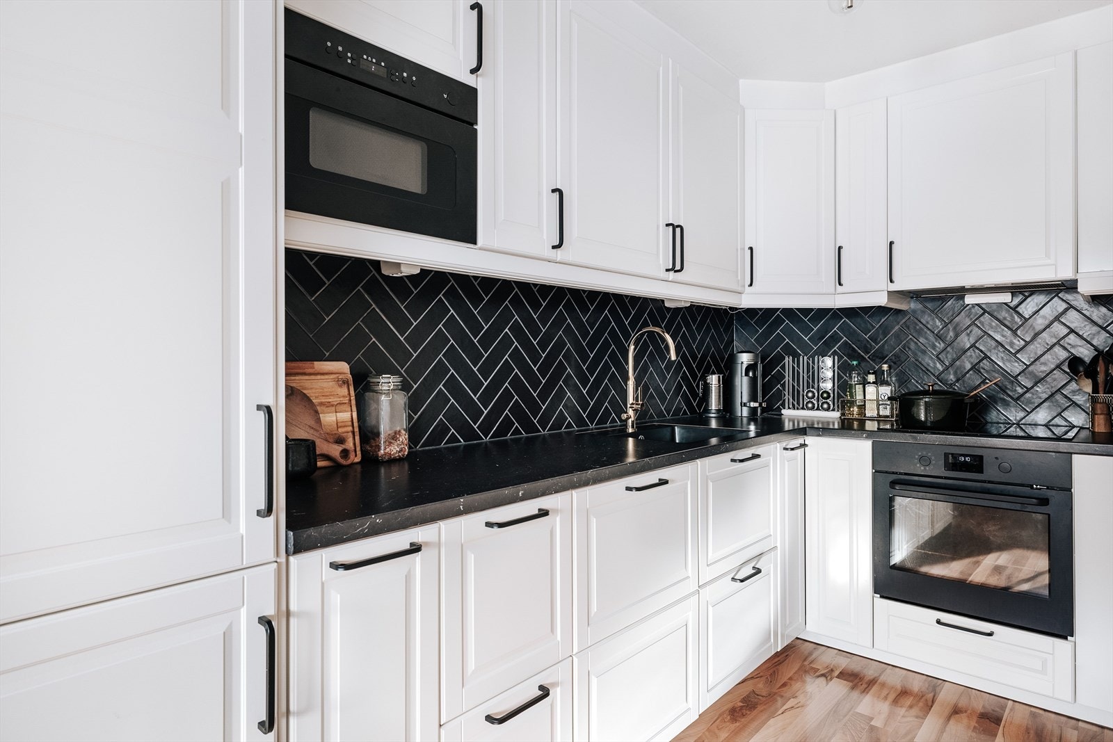 Kjøkkenet har en pen innredning fra 2019 med hvite, profilerte fronter. Laminert benkeplate med nedfelt oppvaskkum. I benkeryggen er det fliser i fiskebeinsmønster. Galleribilde