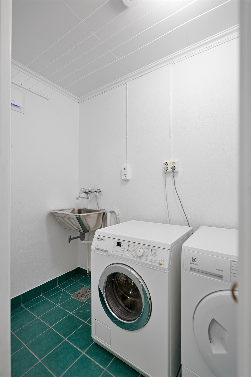 Praktisk vaskerom med opplegg for vaskemaskin samt utslagsvask. Galleribilde