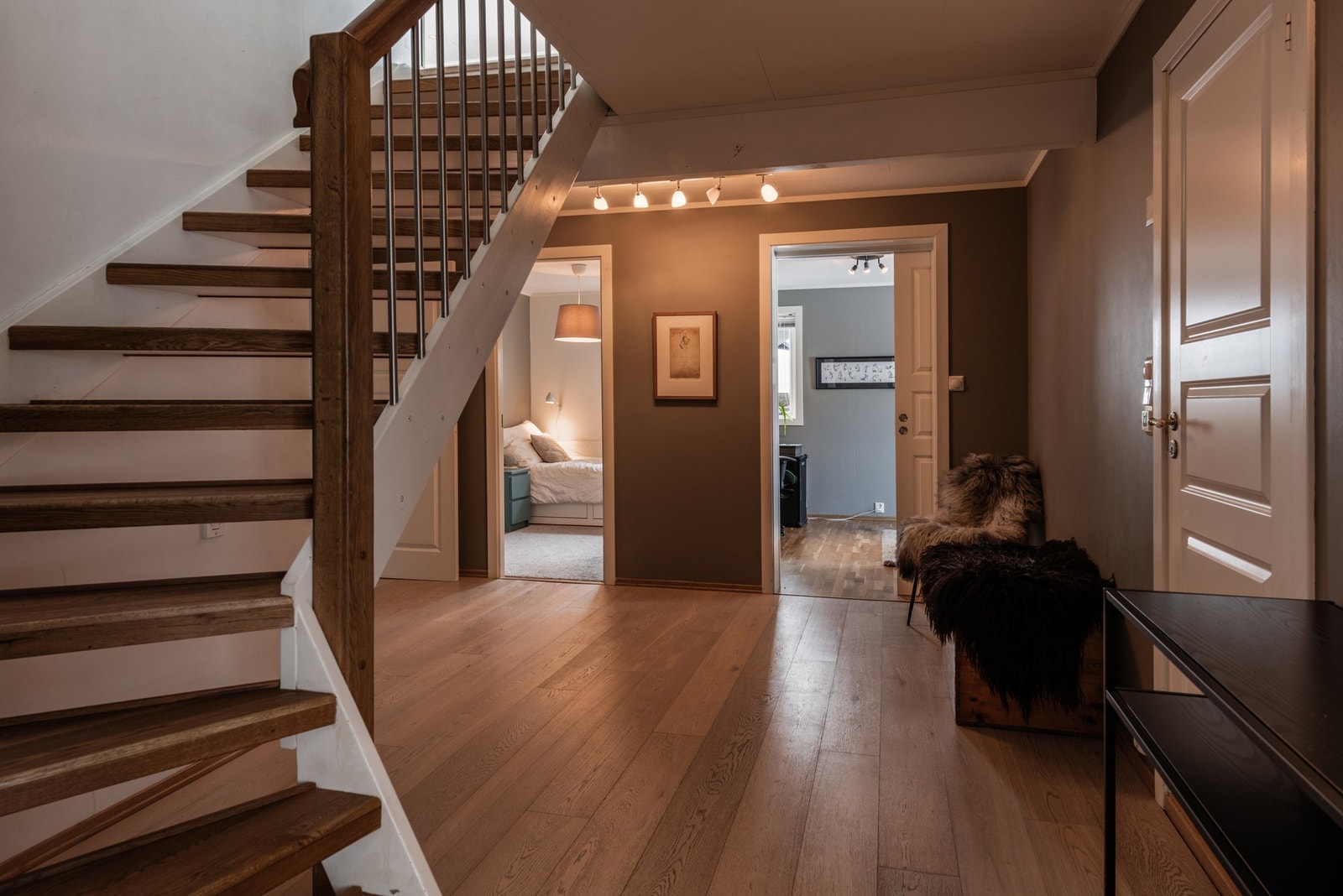 Romslig gang med tilkomst til rommene i underetasjen. Trappen leder til boligens hovedetasjen Galleribilde