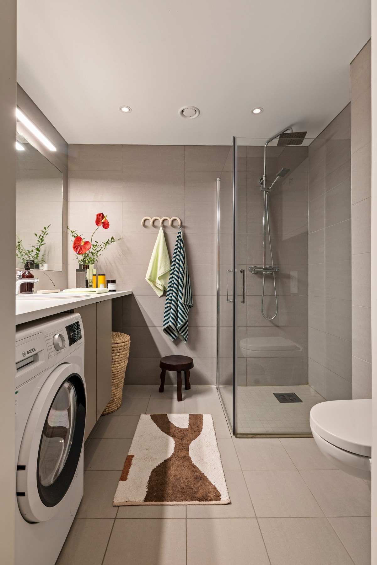 Delikat bad i tidløse farger og med plass til både vaskemaskin og tørketrommel. Galleribilde