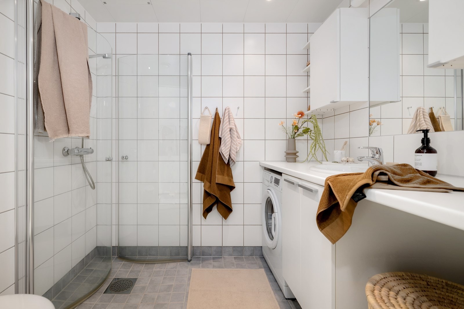 Lang benkeløsning med opplegg for både vaskemaskin og tørgetrommel under. Galleribilde