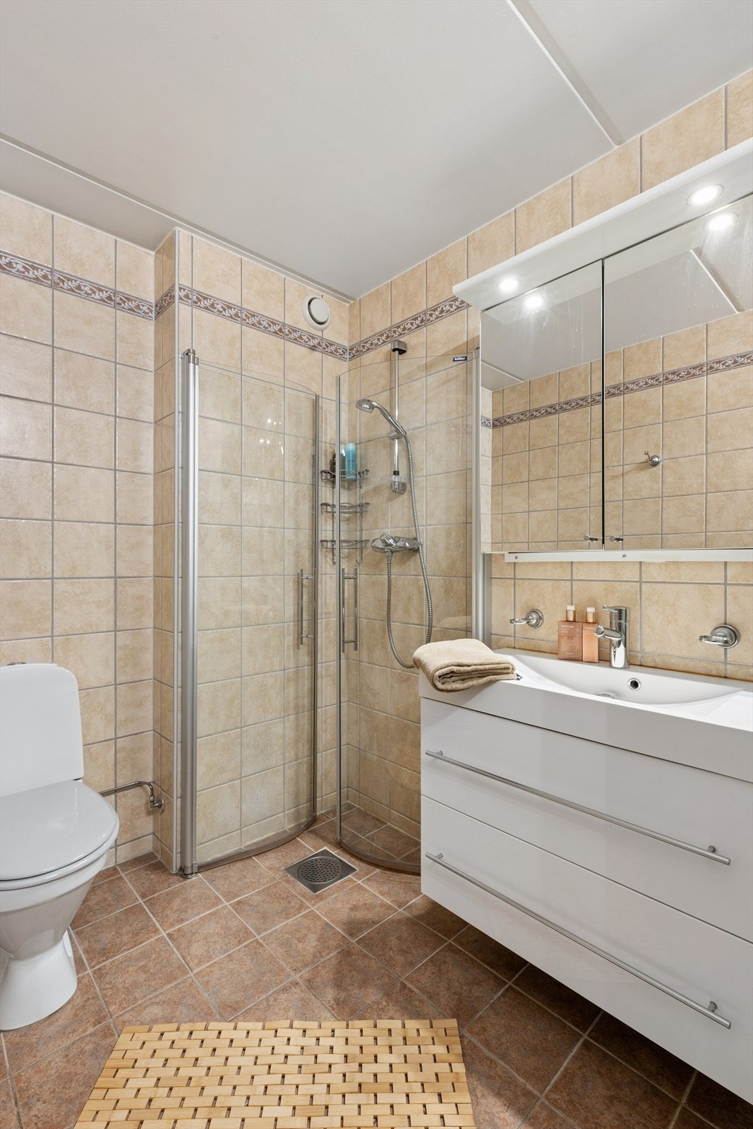 Her er det dusjhjørne, servantinnredning med skuffer og praktisk opplegg for vaskemaskin. Galleribilde