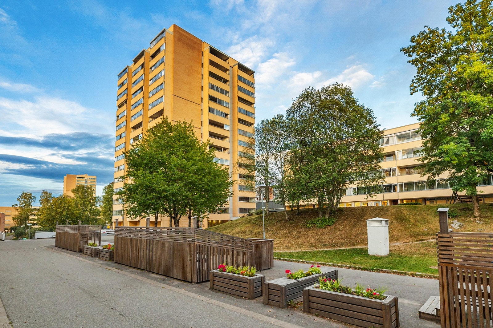 Borettslaget er opparbeidet med plen, trær og planter rundt byggene Galleribilde