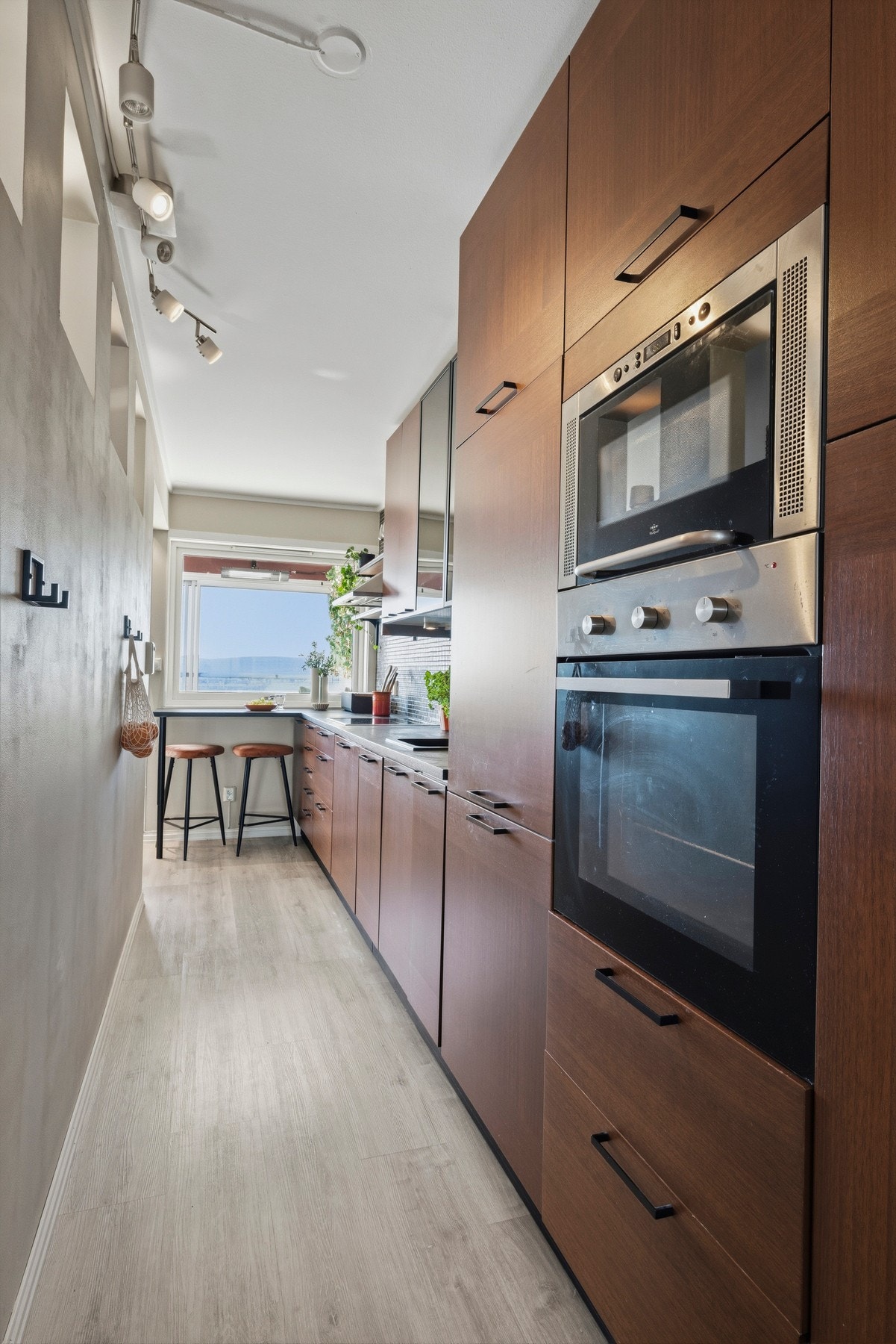 Kjøkkeninnredningen er takoppbygd og plassert langs den ene veggen, med god lagringsplass i over- og benkeskap Galleribilde