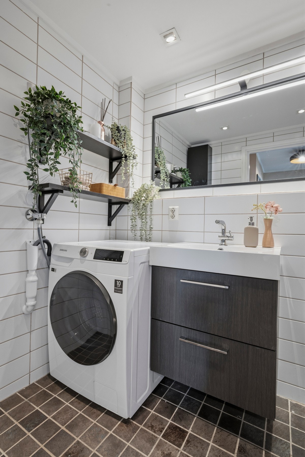 Innredningen består av skap med glatte fronter, hyller, servant, vegghengt toalett og opplegg for vaskemaskin Galleribilde