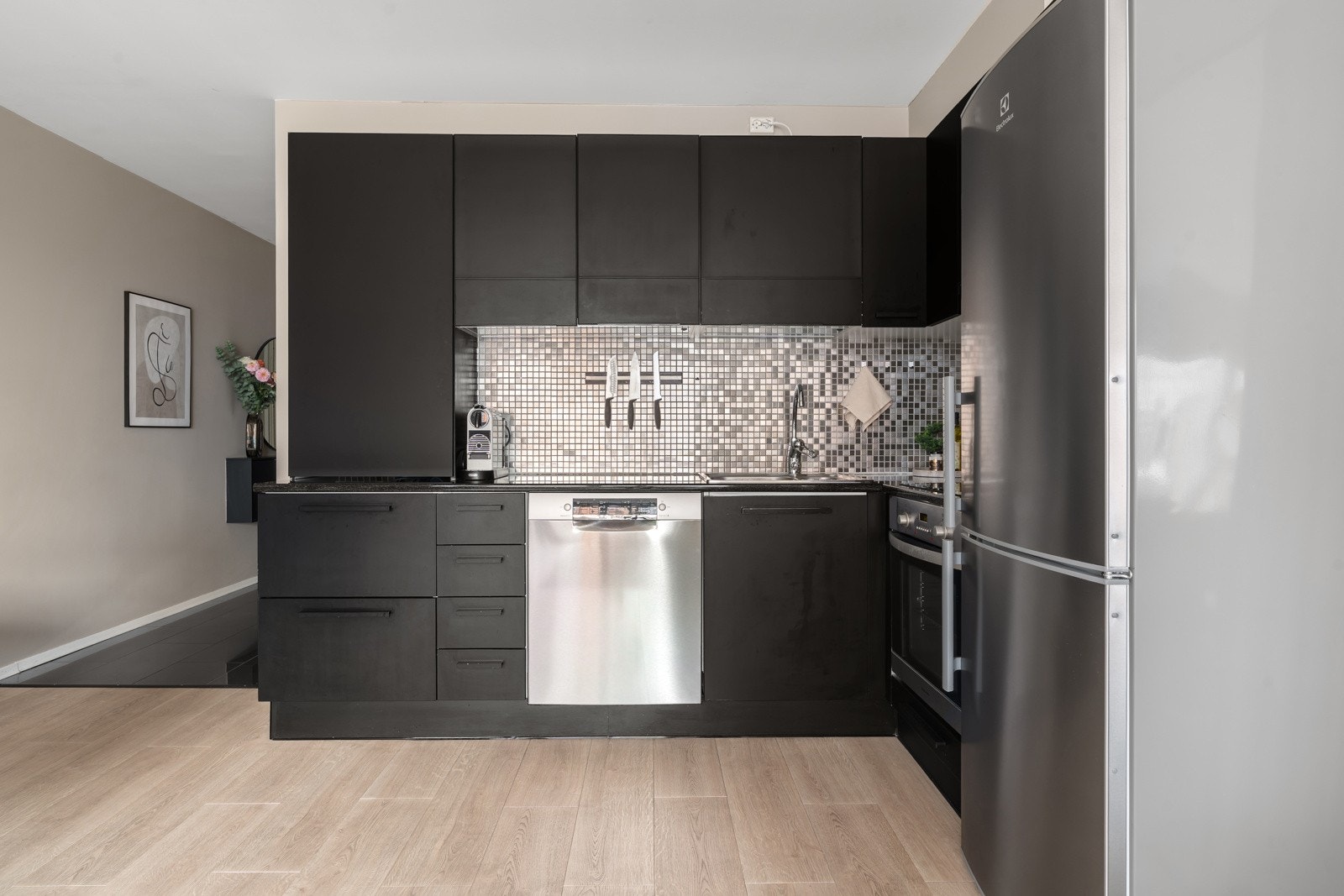 Stilrent kjøkken med mørke fronter skaper et moderne uttrykk og kontrast.