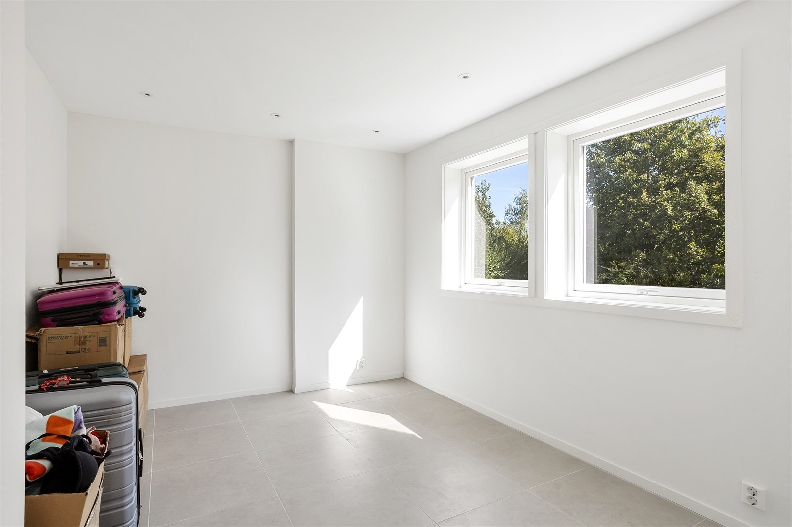 Stilrent med store gulvfliser og downlights. Vinduer mot grønne omgivelser. Galleribilde