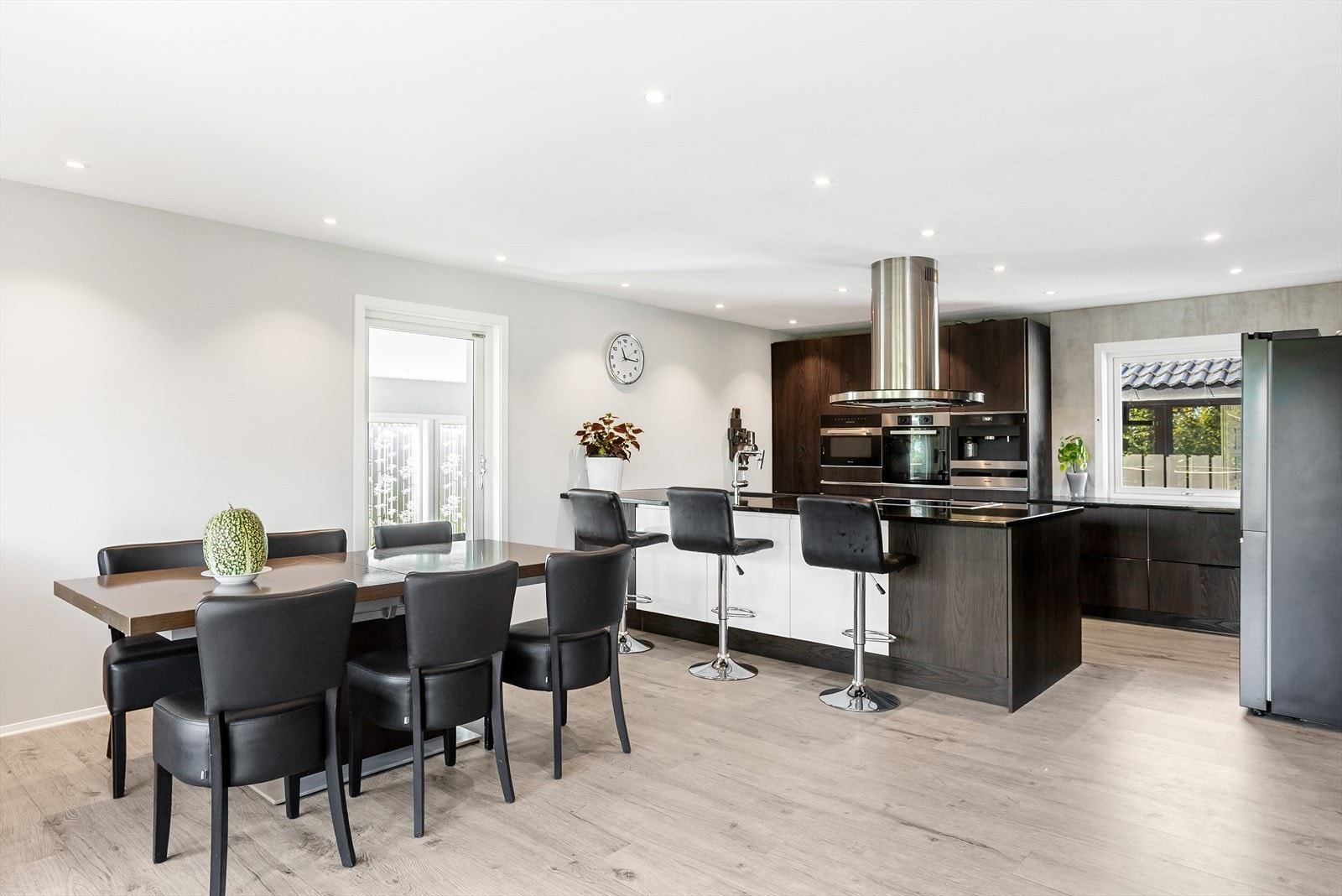 Moderne og sosialt kjøkken med stor øy og integrerte hvitevarer. Galleribilde