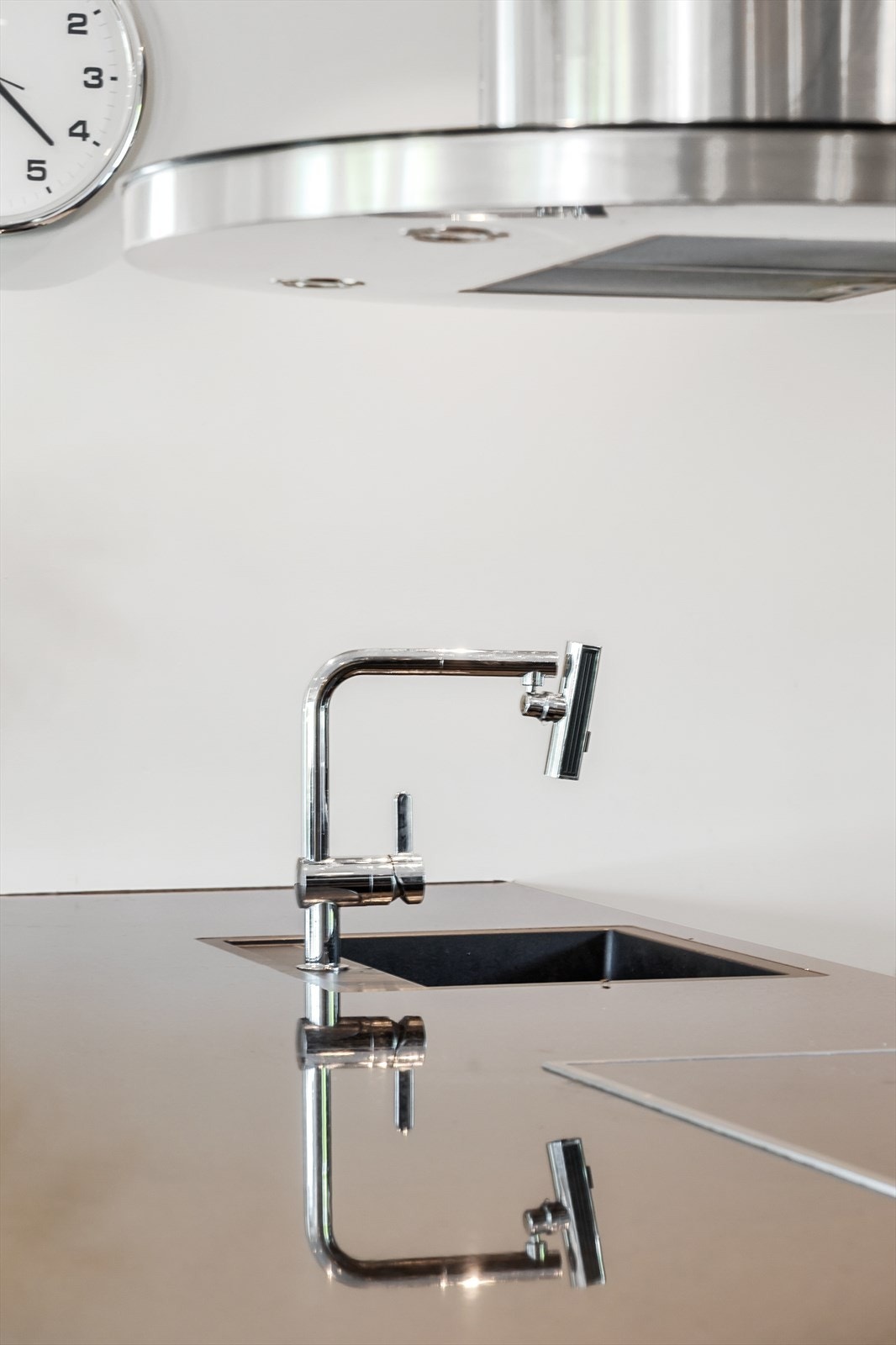 Stilrent kjøkken med eksklusivt armatur og integrert ventilator. Galleribilde