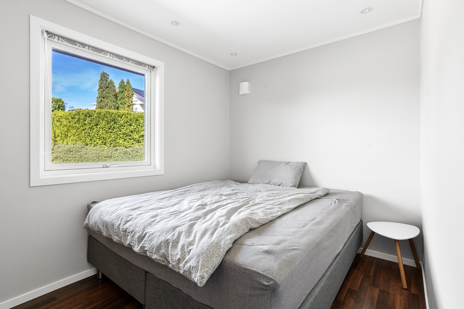 Slette vegger, mørkt gulv og et fredfullt utsyn mot grønne, usjenerte omgivelser. Galleribilde