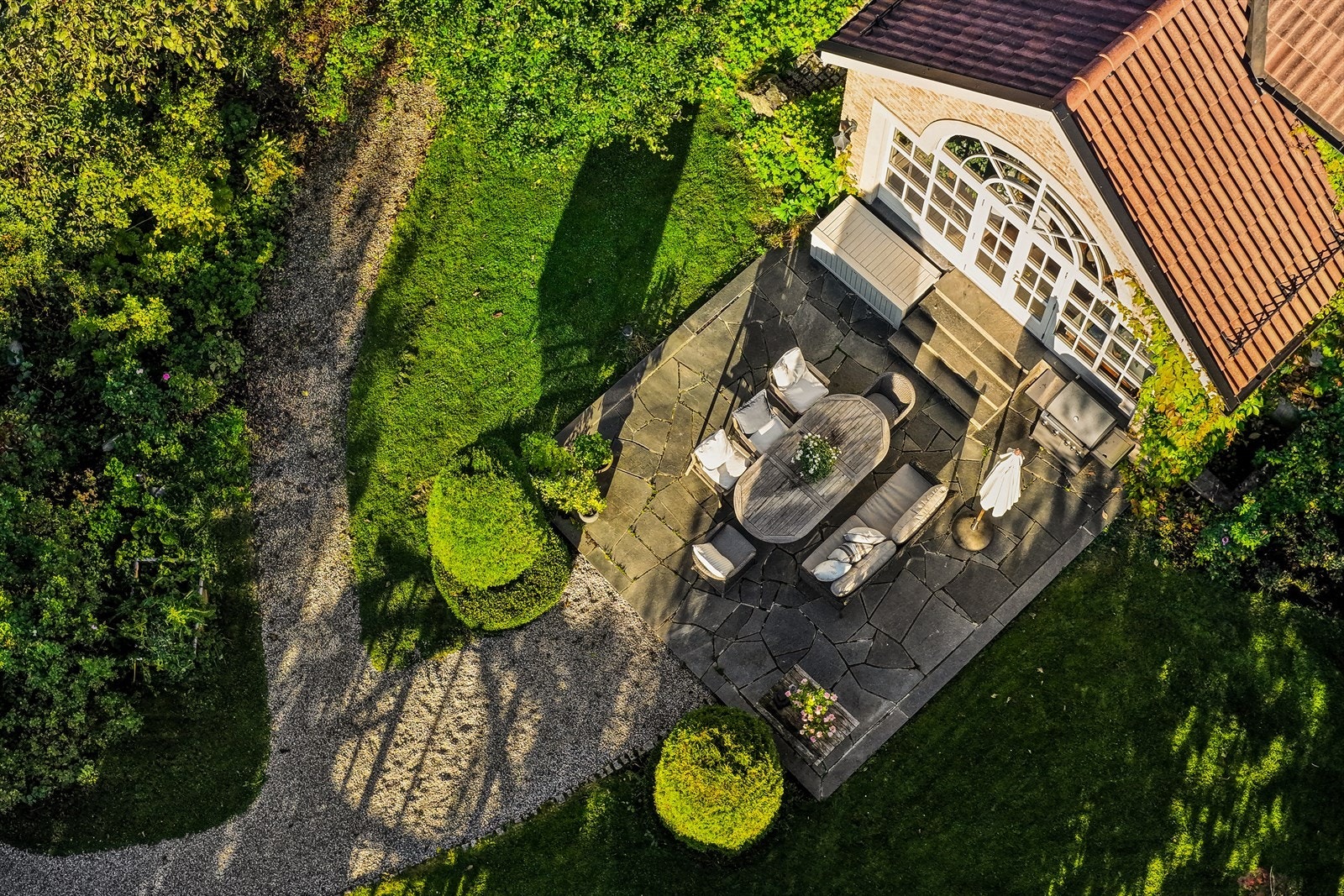 Det er gangveier belagt med grus samt utvendige uteplasser med skifer Galleribilde