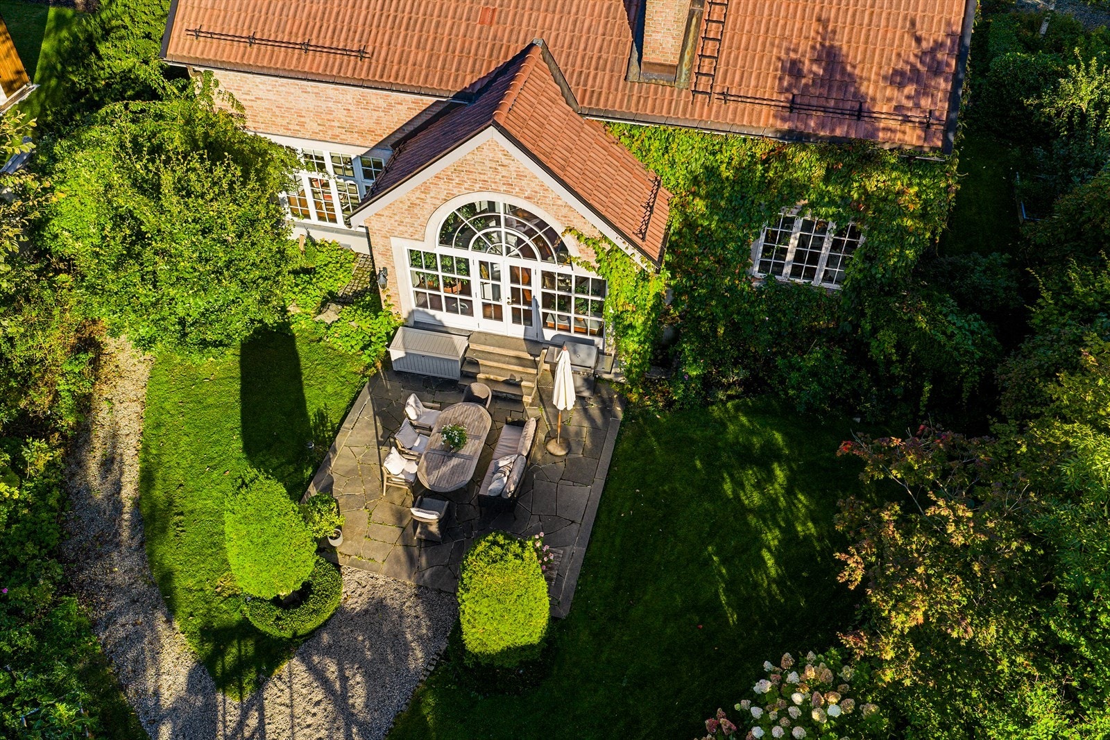 Tomten er relativt flat og pent opparbeidet med hage Galleribilde