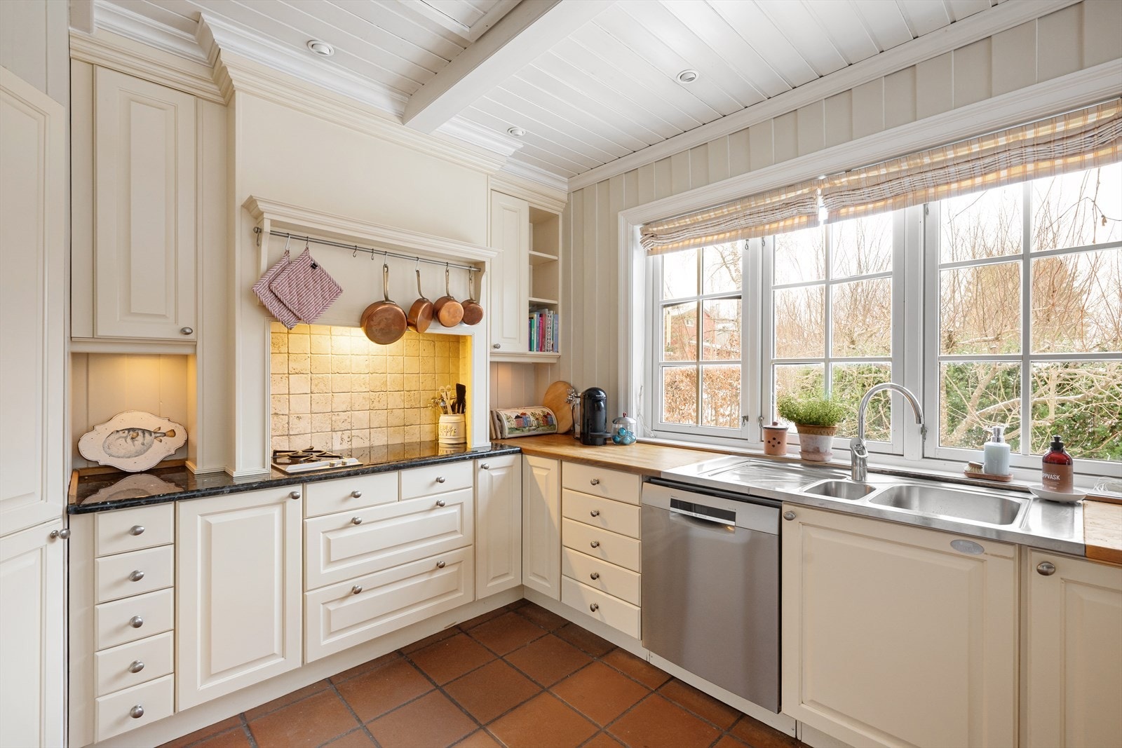 Innredning med profilerte fronter, heltre benkeplate, underlimt dobbel vask og kjøkkenventilator med avtrekk ut Galleribilde