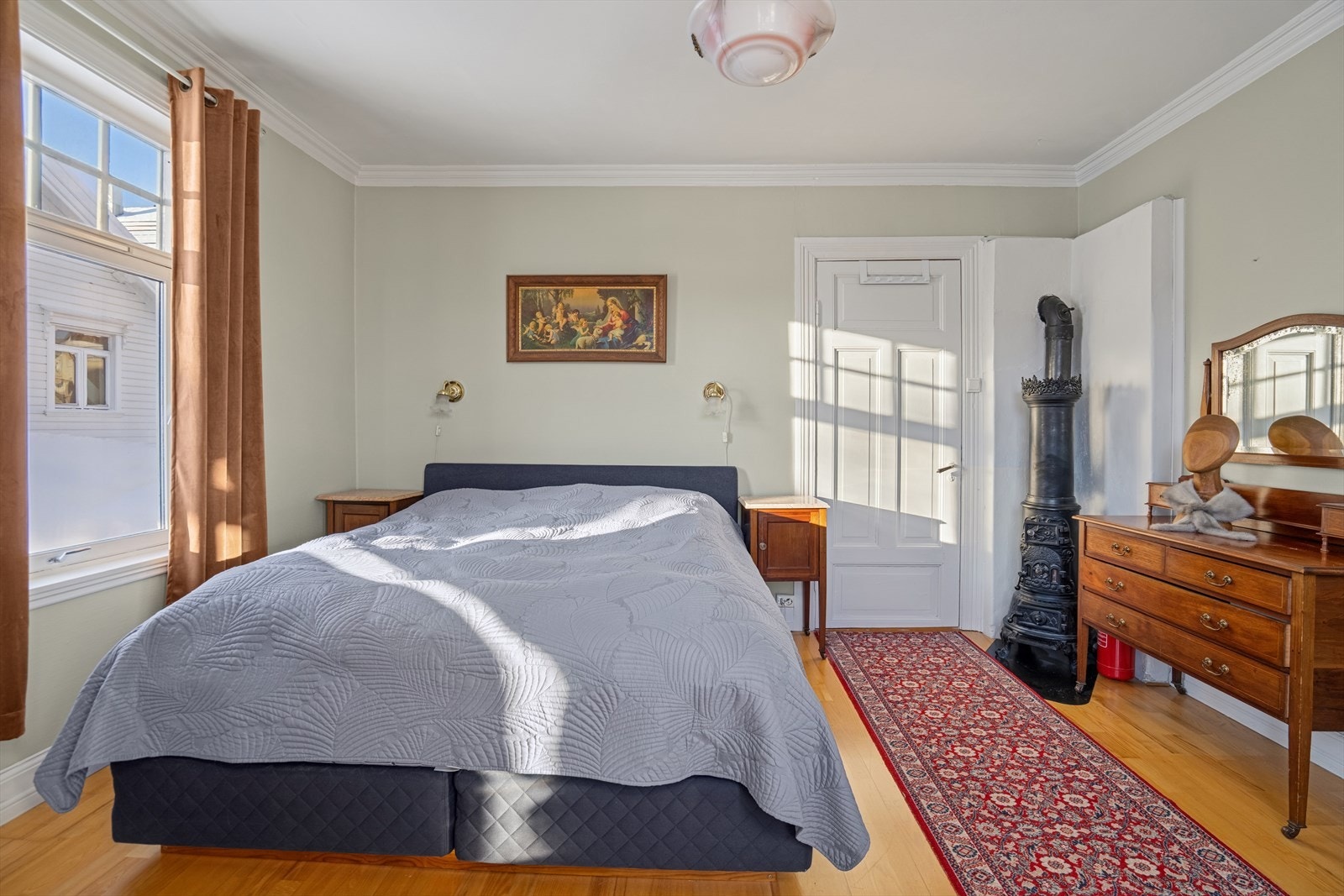 Hovedsoverommet er romslig og har en klassisk etasjeovn som et dekorativt element. Galleribilde