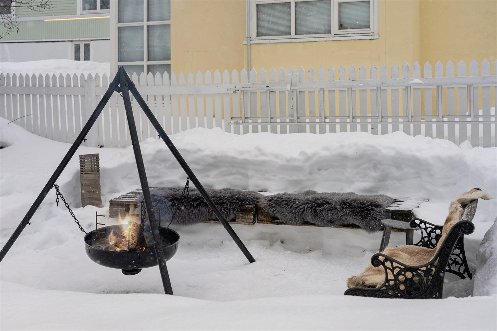 Hage på sør- og vestsiden av boligen, koselig innredet med bålplass, to plattinger, gressplen og prydbusker. Galleribilde