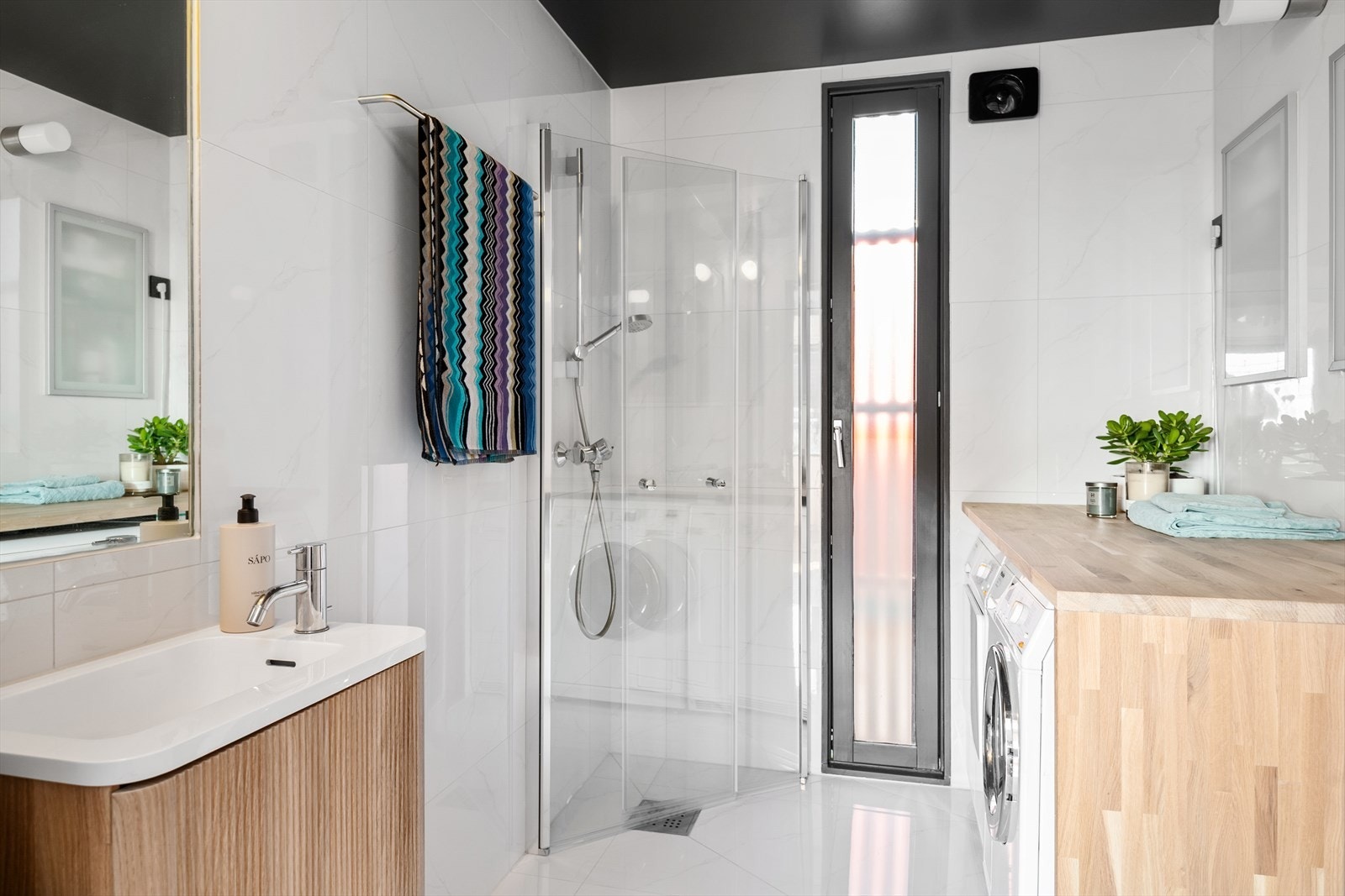 Boligens hovedbad ligger praktisk til ved gangen og har flislagte overflater. Galleribilde