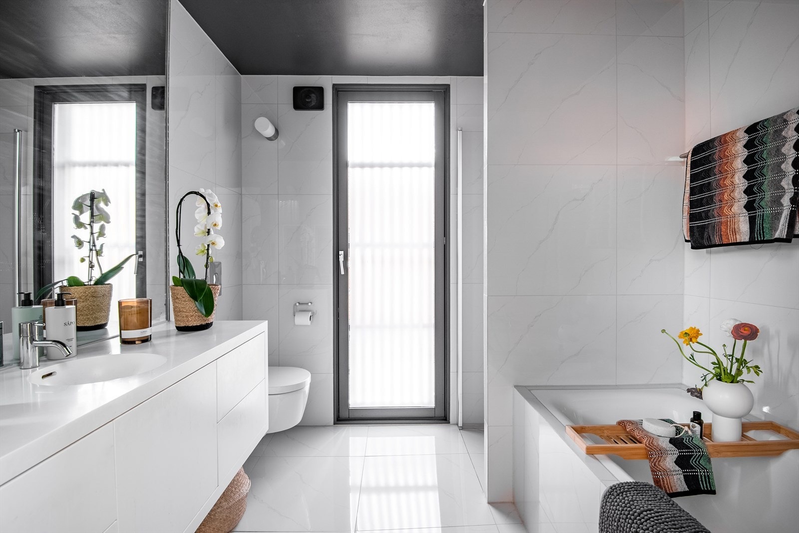 Tilknyttet hovedsoverommet ligger et romslig bad med flislagte overflater. Galleribilde