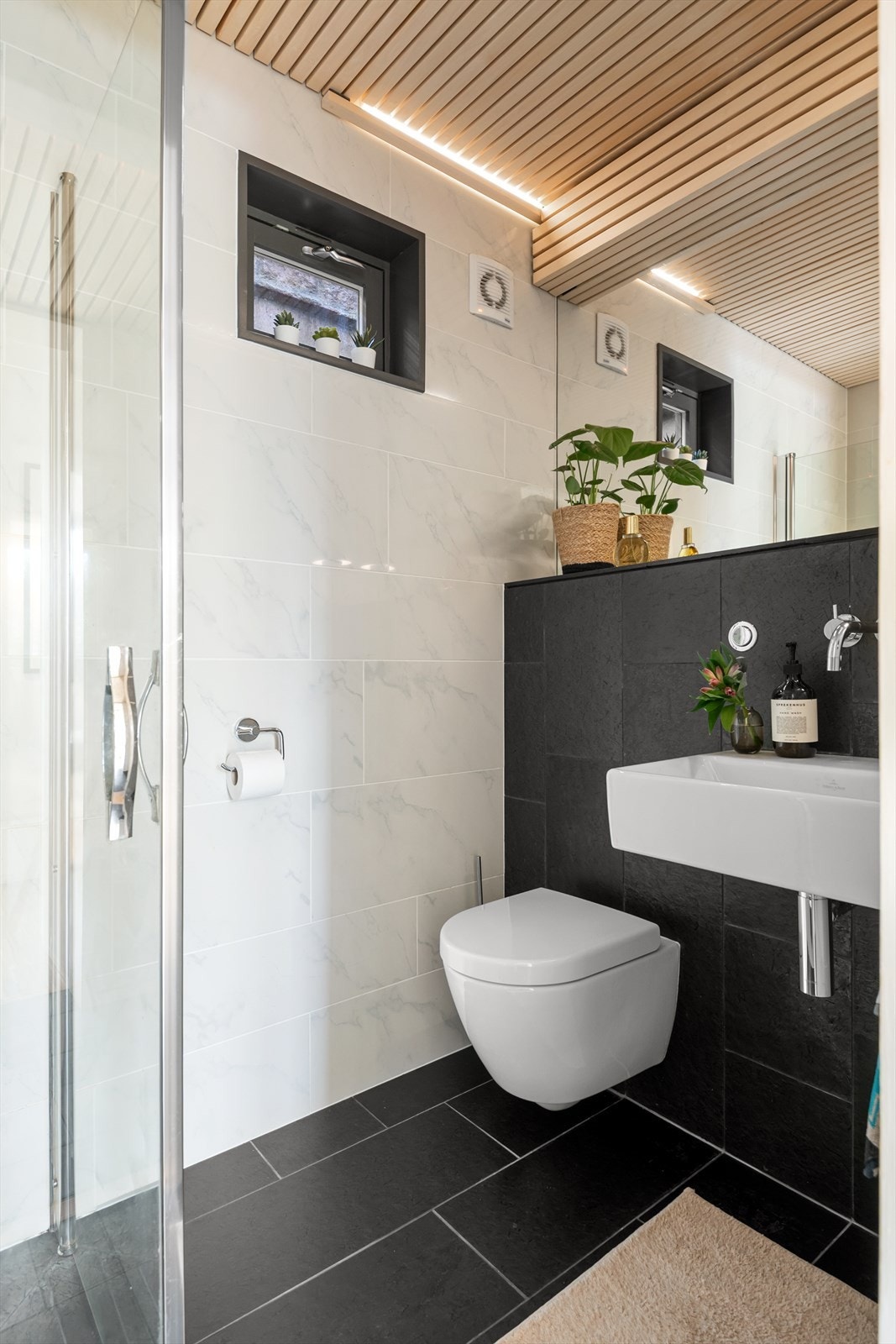 Badet i underetasjen er flislagt og inneholder servant, toalett og dusjløsning. Galleribilde