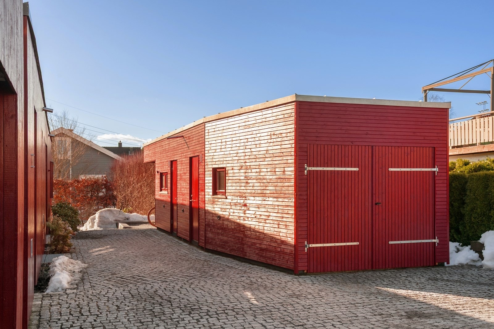 Garasjebygget har et moderne uttrykk som harmonerer med boligen. Her finnes også en praktisk smørebod til glede for alle skientusiaster samt utendørs sykkelparkering med takoverbygg. Galleribilde