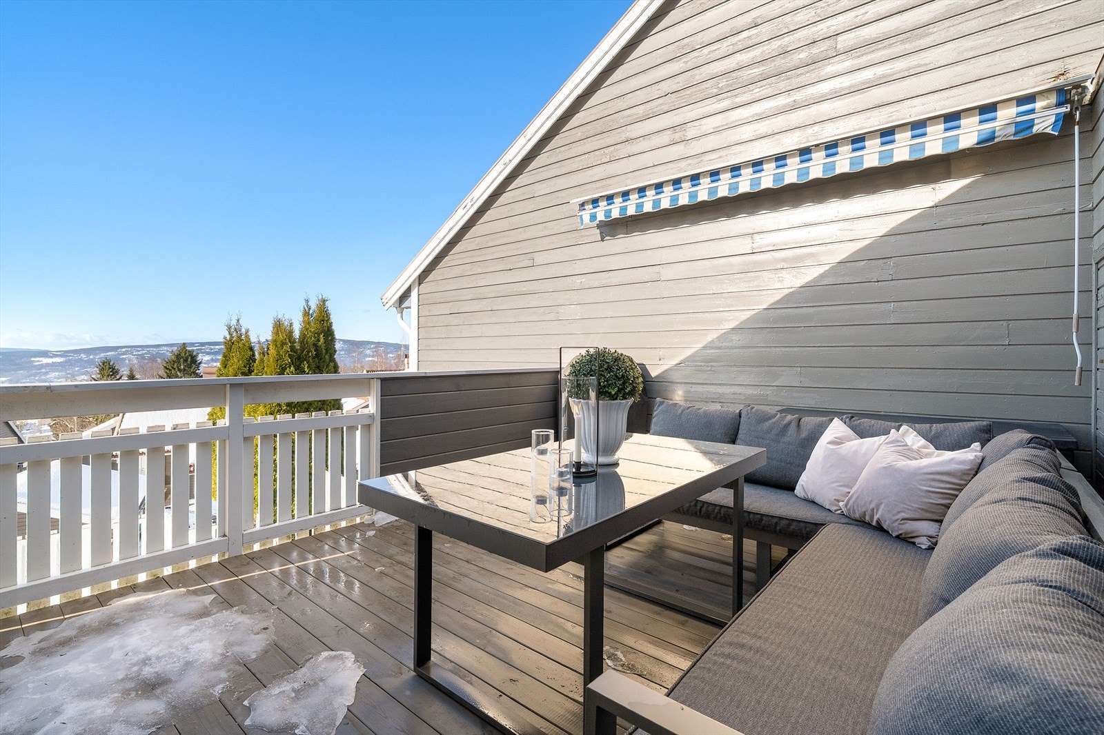 Verandaen er usjenert med skjermende vegg og veggmontert markise som skjermer for solen ved behov. Galleribilde