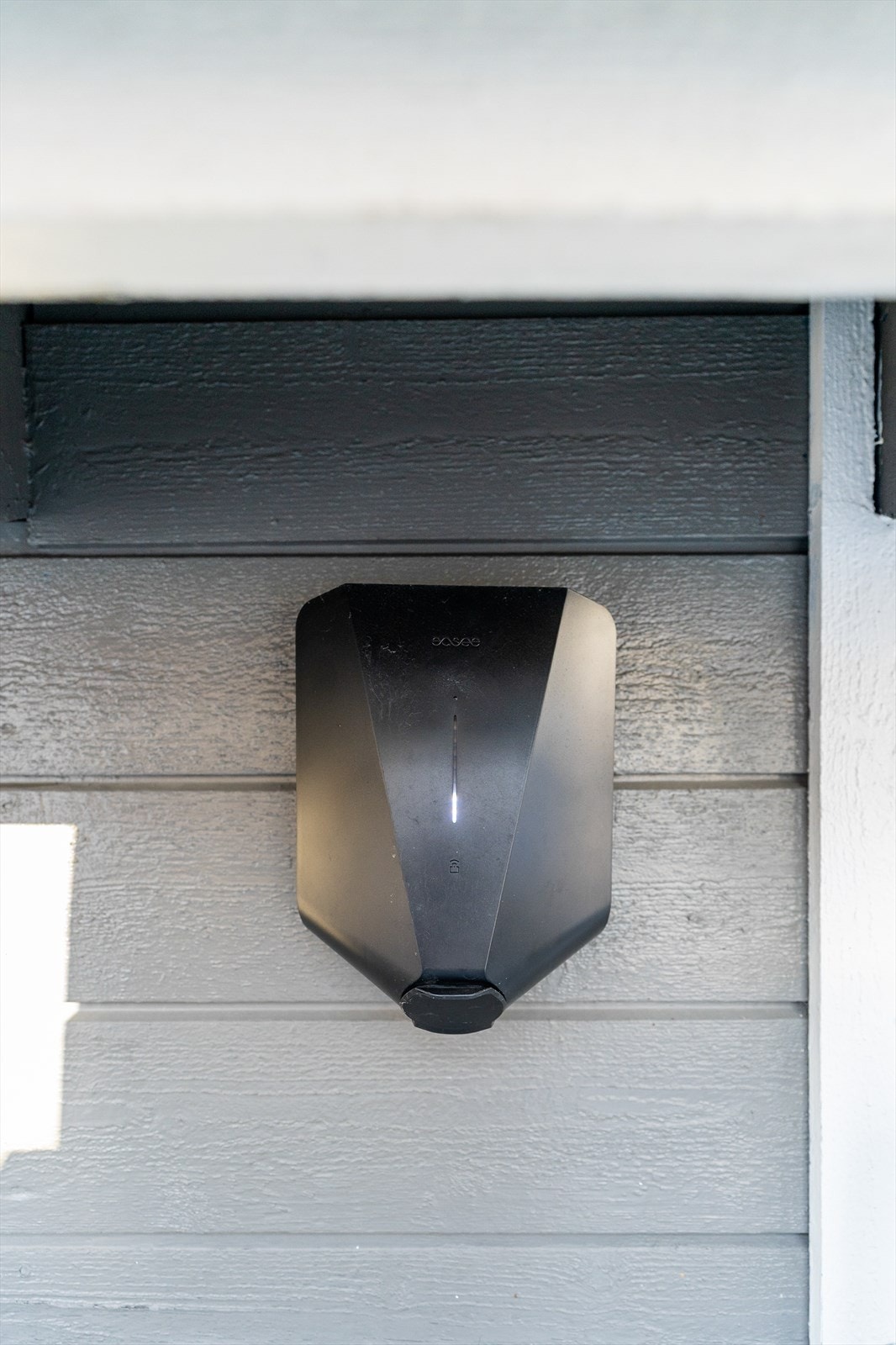 El.bil-lader er montert på garasjeveggen. Galleribilde