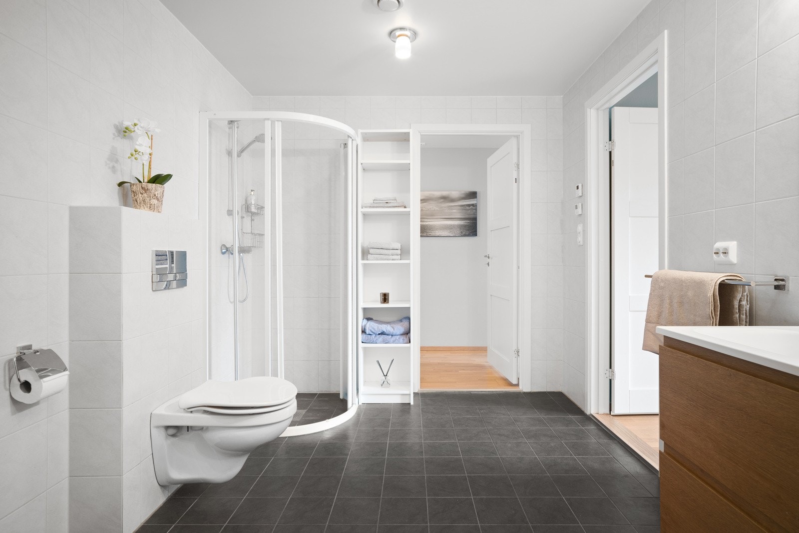 . Innredningen består av en praktisk baderomsinnredning med dobbel servant, veggskap, vegghengt toalett og dusjhjørne. Galleribilde