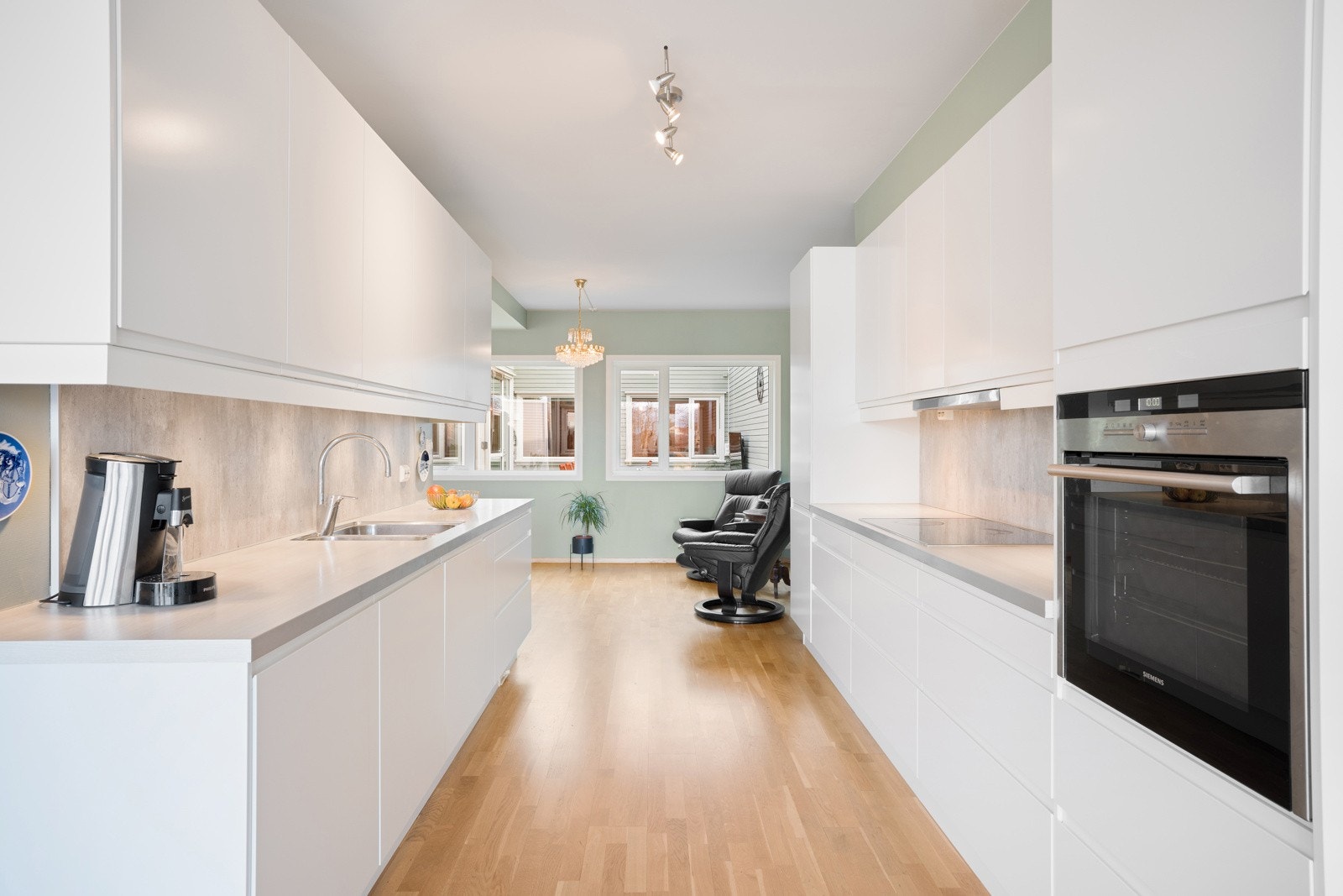 Kjøkkenet har en tidløs innredning bestående av slette, grepsfrie fronter og benkeplate i laminat. Galleribilde