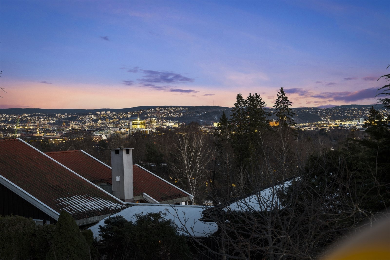 Nyt utsikten over Oslo fra stuen, med byens lys som skaper en magisk atmosfære når kvelden kommer. Galleribilde