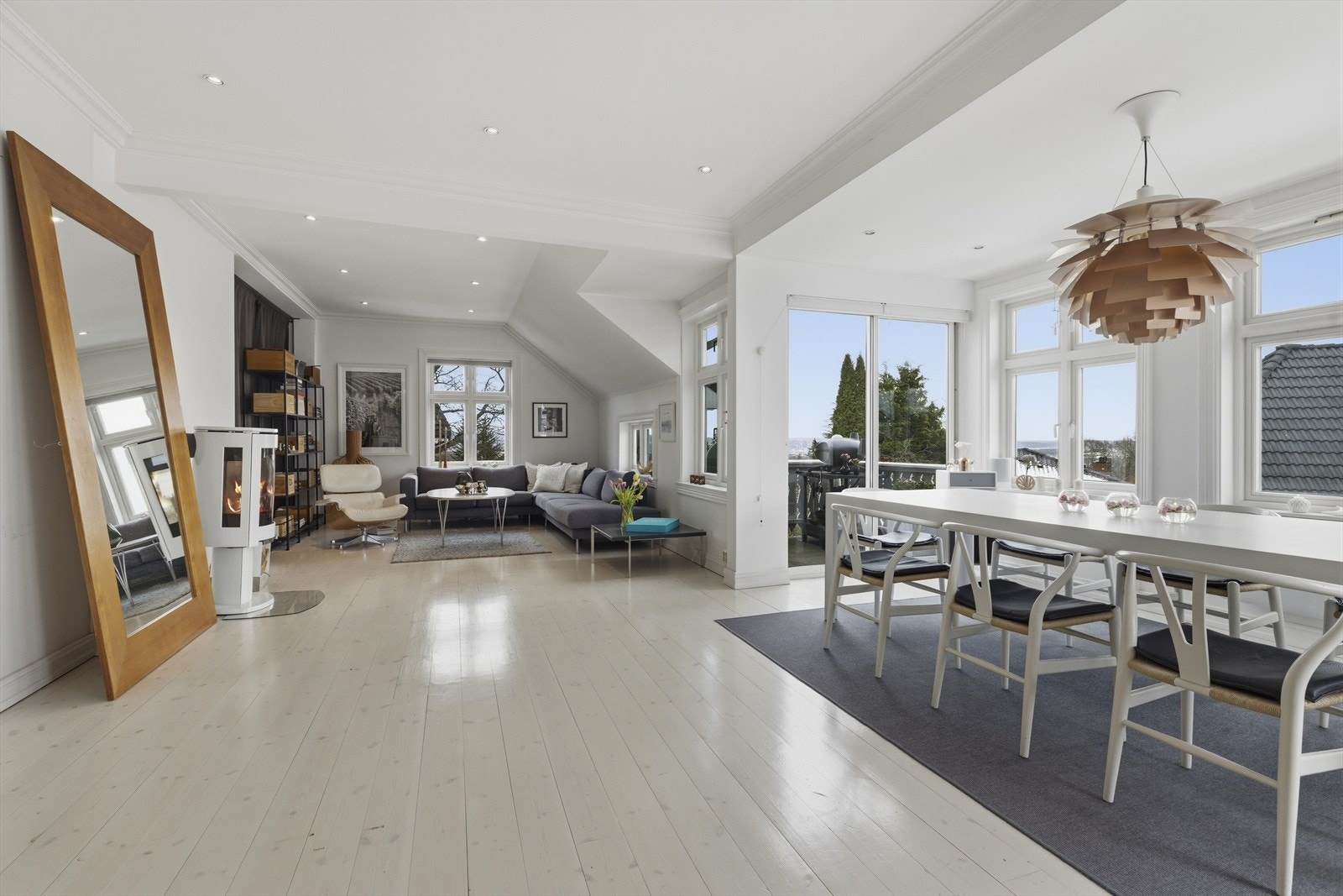 Stuen fylles av naturlig lys gjennom store vinduer, med en åpen og luftig atmosfære. Galleribilde