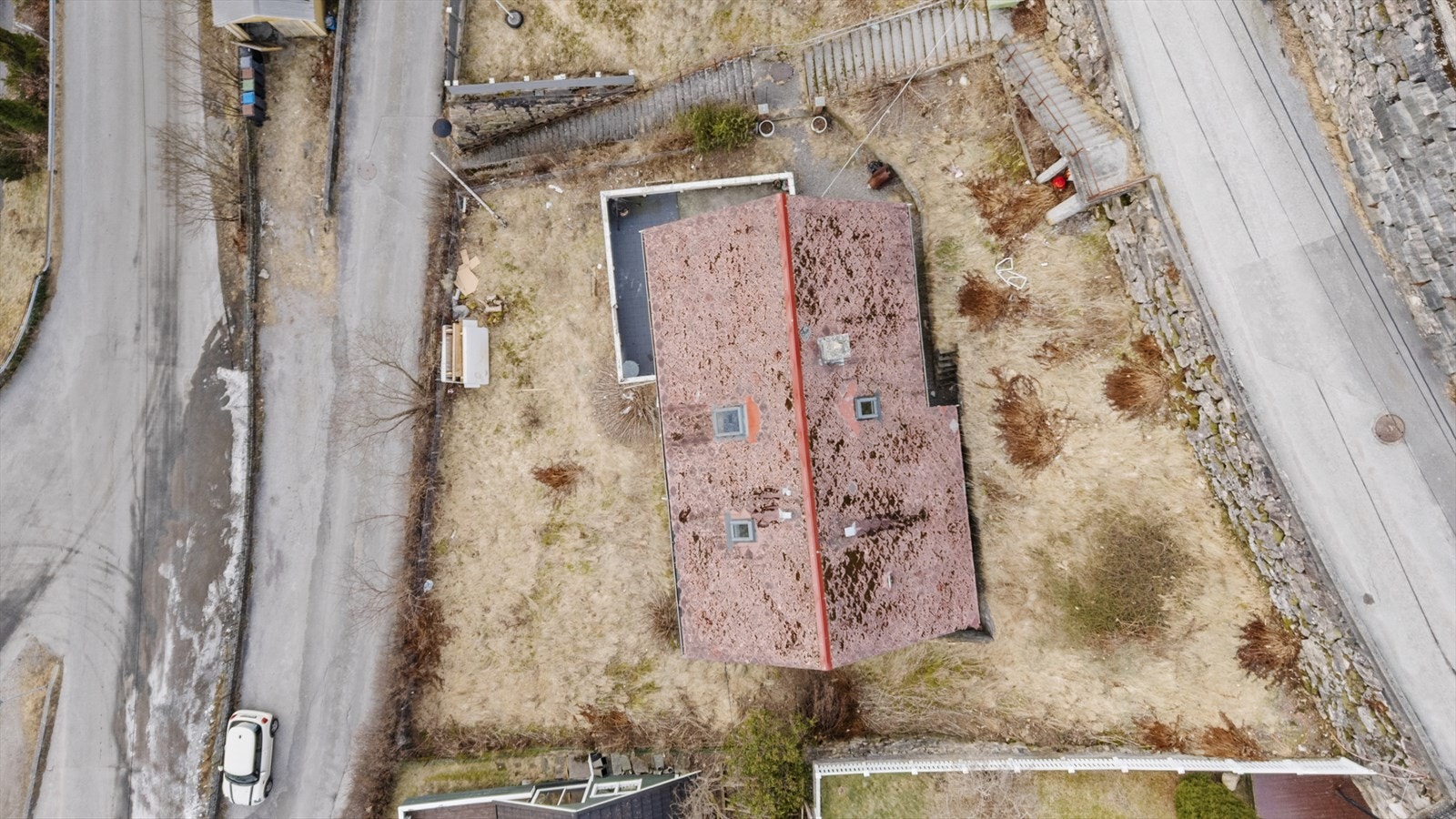 Oversiktsbilde - bustaden har adkomst via trapp frå vegen på opp- og nedsida av eigedommen Galleribilde