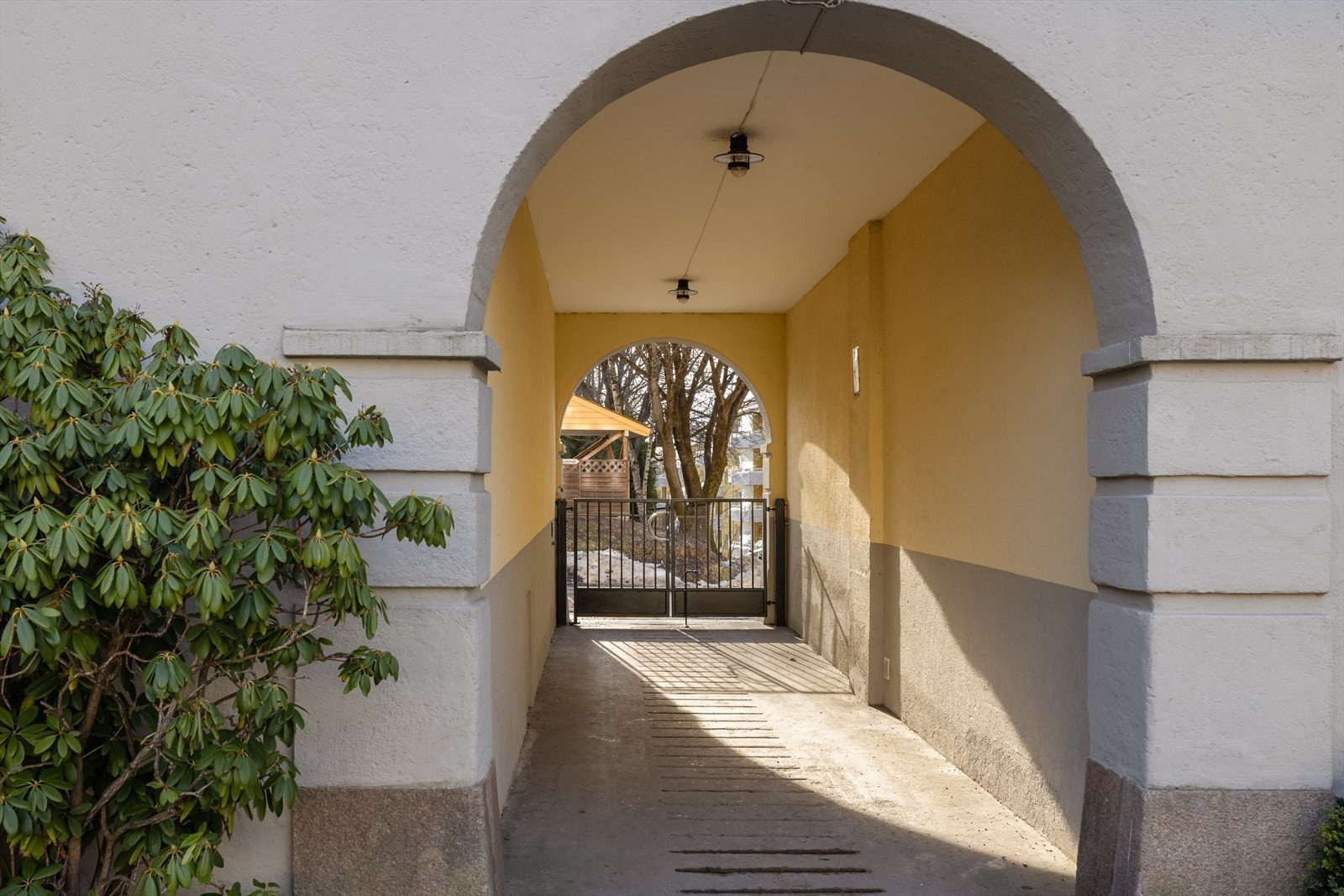 Den karakteristiske portalen leder inn til det frodige gårdsrommet. Galleribilde