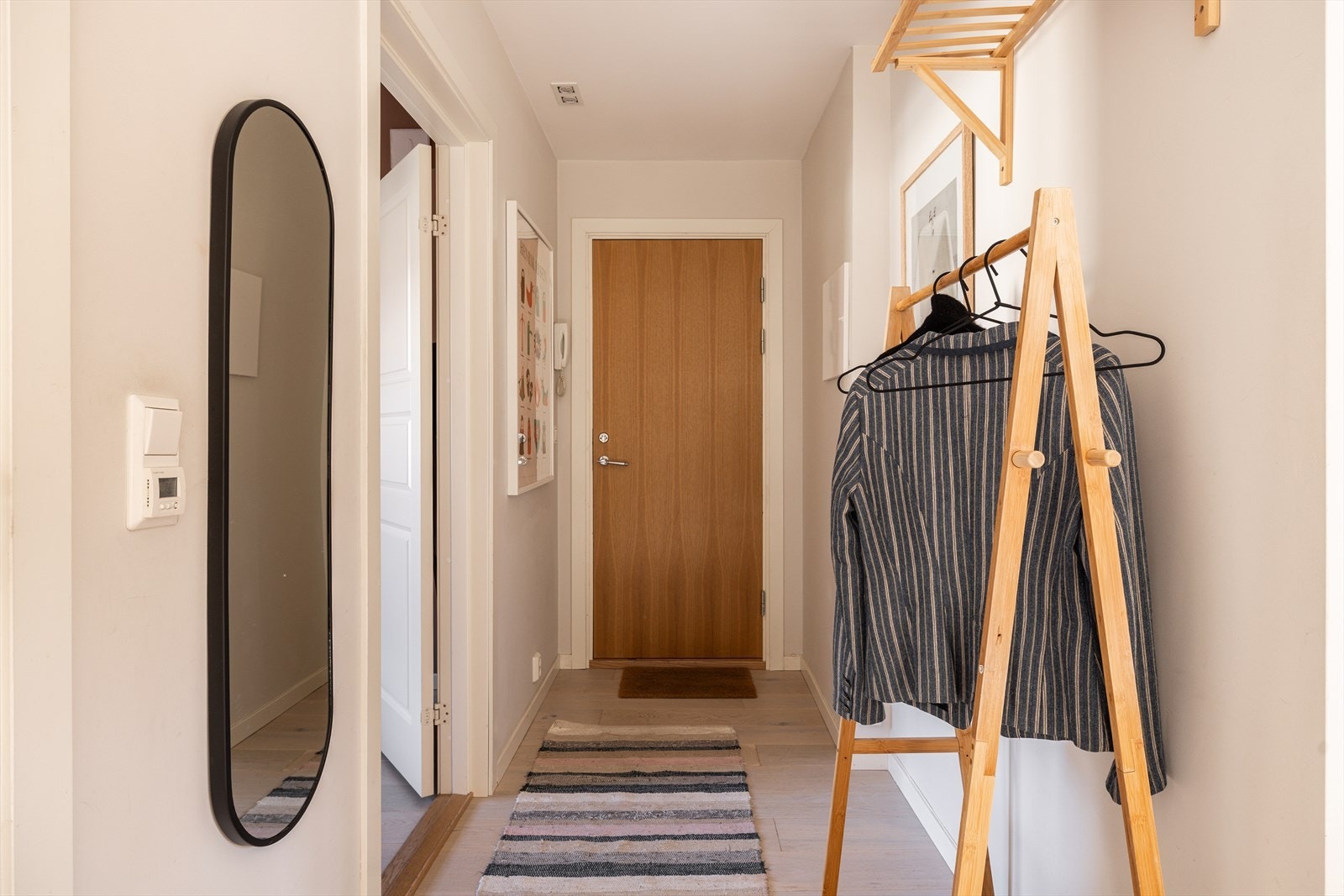 Lys entré med med gjennomgående 1-stavs hvitpigmentert eikeparkett. Galleribilde