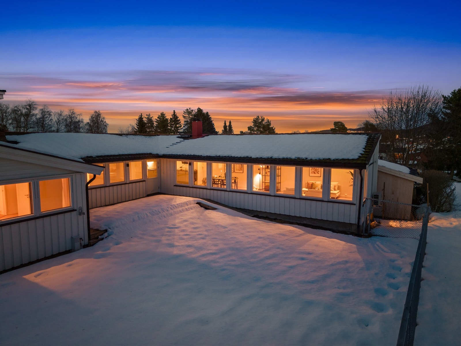 Den snødekte hagen gir et fredelig vinterbilde, mens terrassen og uteområdet under venter på lange og solrike dager når våren melder sin ankomst. Galleribilde